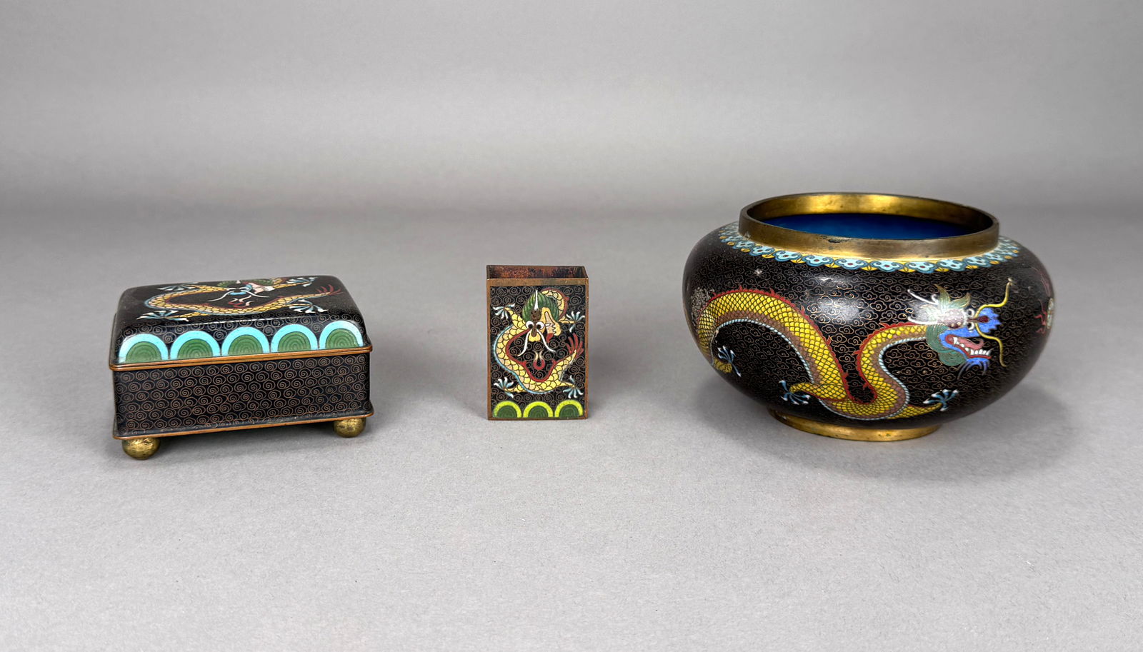 Three Chinese Cloisonne Enamel Objects: Three Chinese cloisonne enamel objects including a cigarette case, match box, and bowl with dragon motif. Bowl: 5.5"D