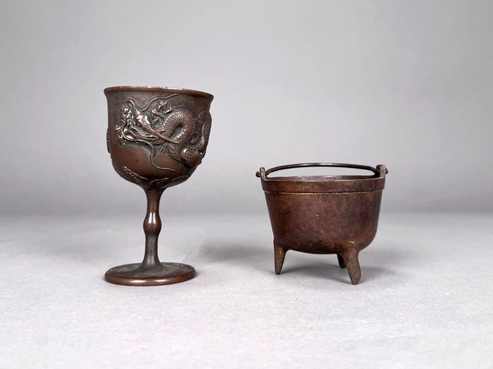 Asian Pewter Chalice and Ding: An Asian Pewter with copper plated chalice with dragon design and miniature ding. Dimensions: Chalice is 4 1/8" tall, 2 1/2" in diameter Ding is 2 1/4" tall, 2 3/4"