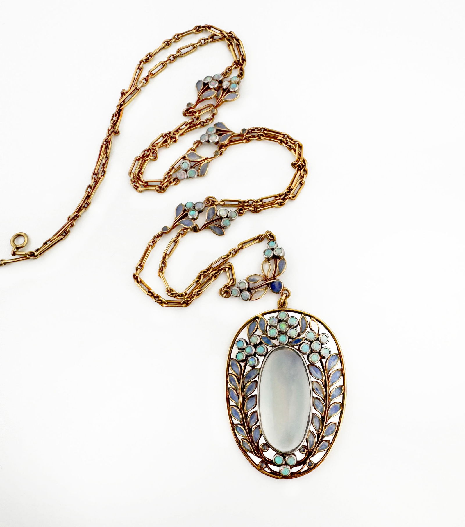 Louis Comfort Tiffany for Tiffany & Co Necklace: Louis Comfort Tiffany for Tiffany & Co, 18k yellow gold set with a cabochon moonstone within a plique-a-jour enamel frame suspended from a gold and plique-a-jour enamel chain, circa 1910 10.4g Pen