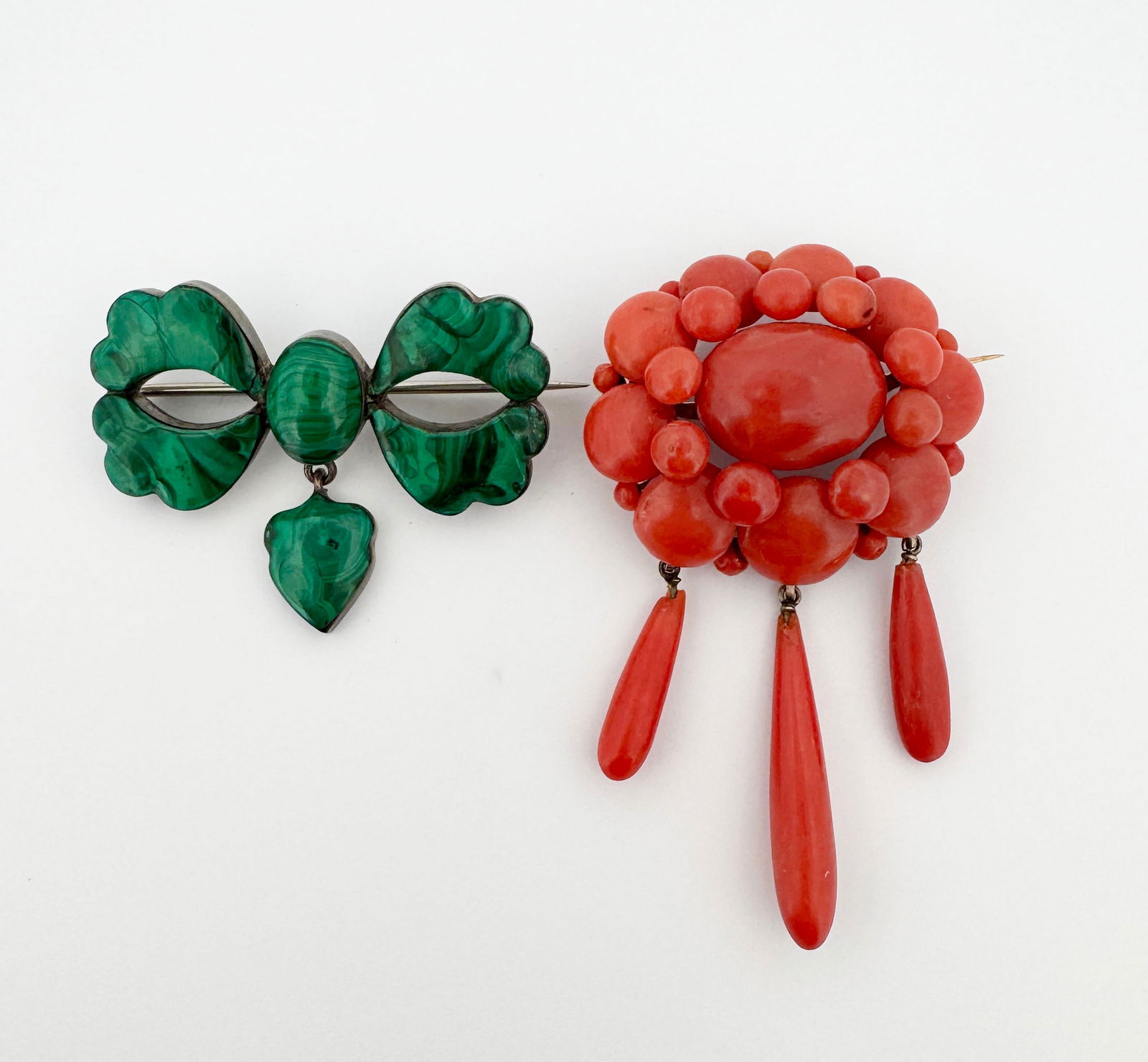 Malachite & Coral Brooches: Silver and malachite bow brooch; golf-filled and coral beaded brooch 32g Coral brooch: 46.6mm long