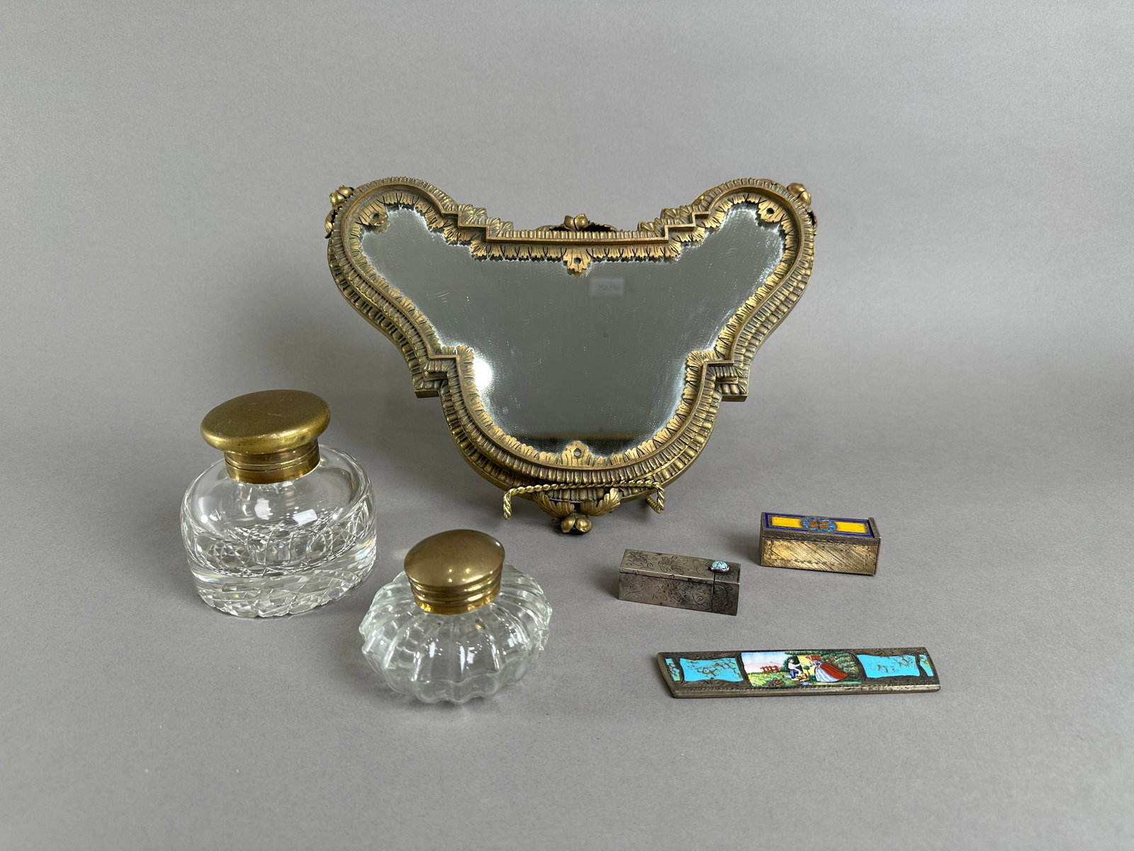 Antique Vanity Set with Mirror, Bottles & Boxes: Antique vanity set featuring an ornate mirror (12" long), two cut glass bottles with metal lids, and several small decorative boxes. Weight: 65 oz.