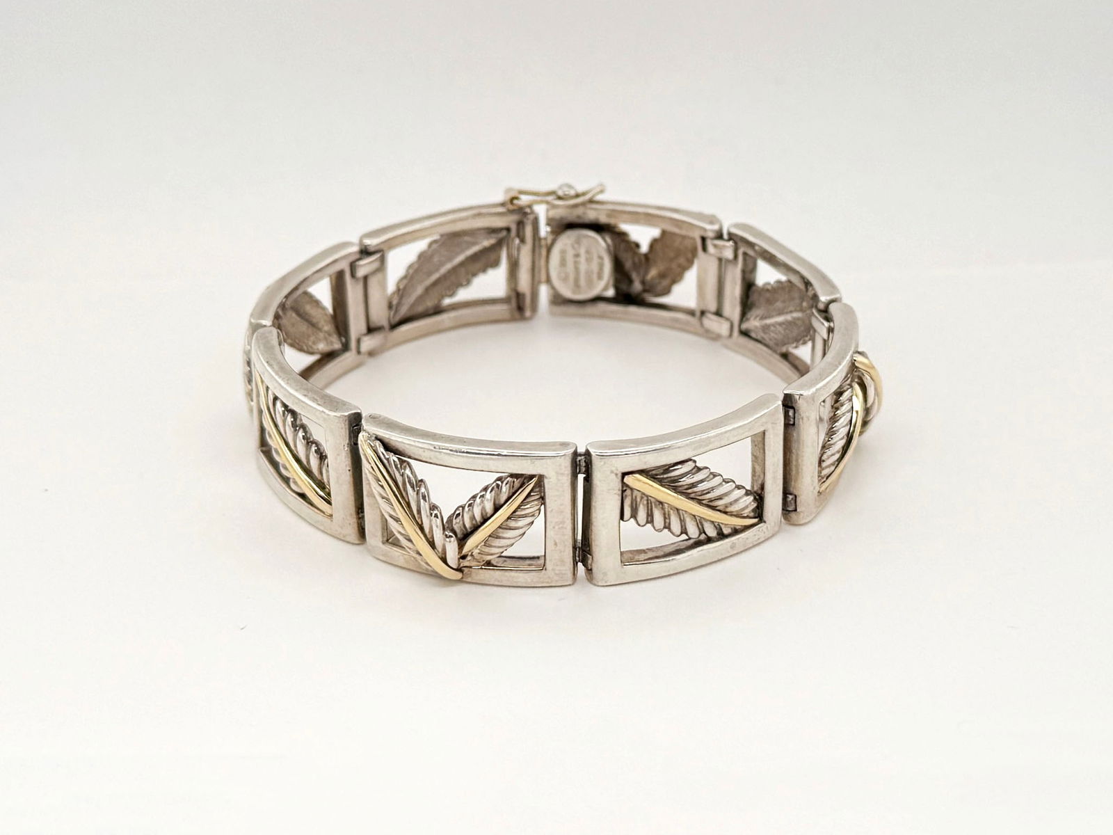 Tiffany and Co 18k and Sterling Bracelet: Tiffany & Co. bracelet featuring sterling silver links with 18k gold leaf accents. Marked Tiffany & Co. 2003, Italy. Measures approximately 7 inches in length. Total weight: 46 grams.