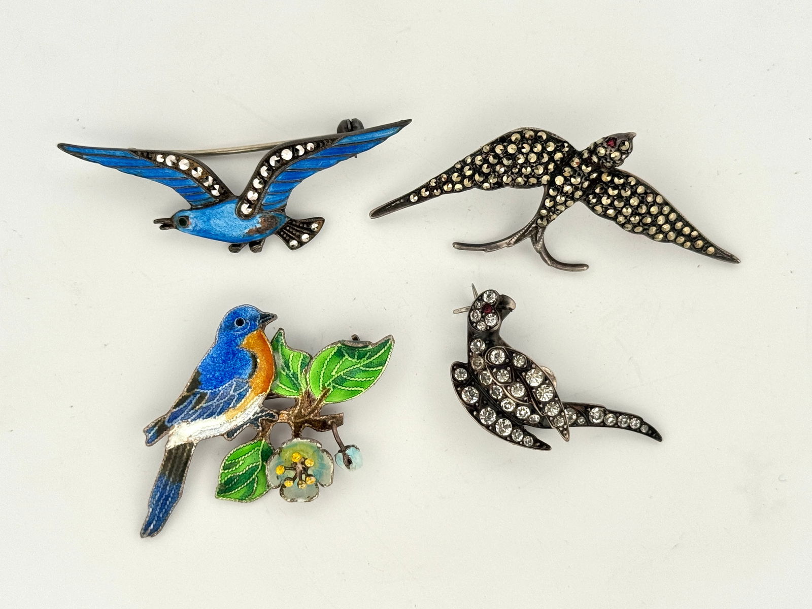Four Enamel & Marcasite Silver Bird Brooches: Four sterling silver bird-shaped brooches with marcasite stones, rhinestones, and enamel detailing. 22g2.125" largest 