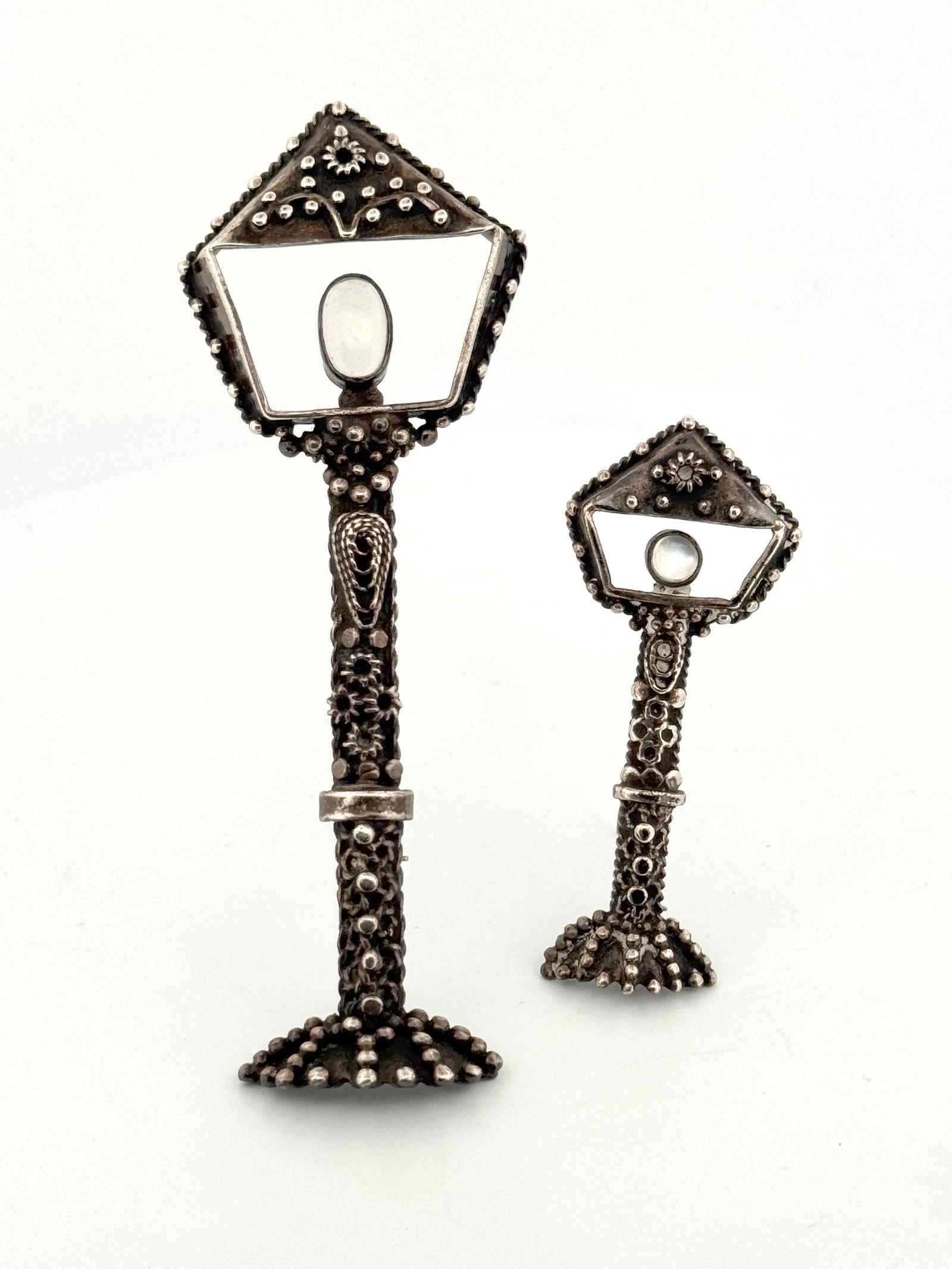 Two Sterling Silver Moonstone Lantern Brooches: Two sterling silver brooches in the shape of lanterns, each set with a moonstone. One marked "Sterling" on reverse. The larger pin is approximately 4 inches long and the total weight is 32g.