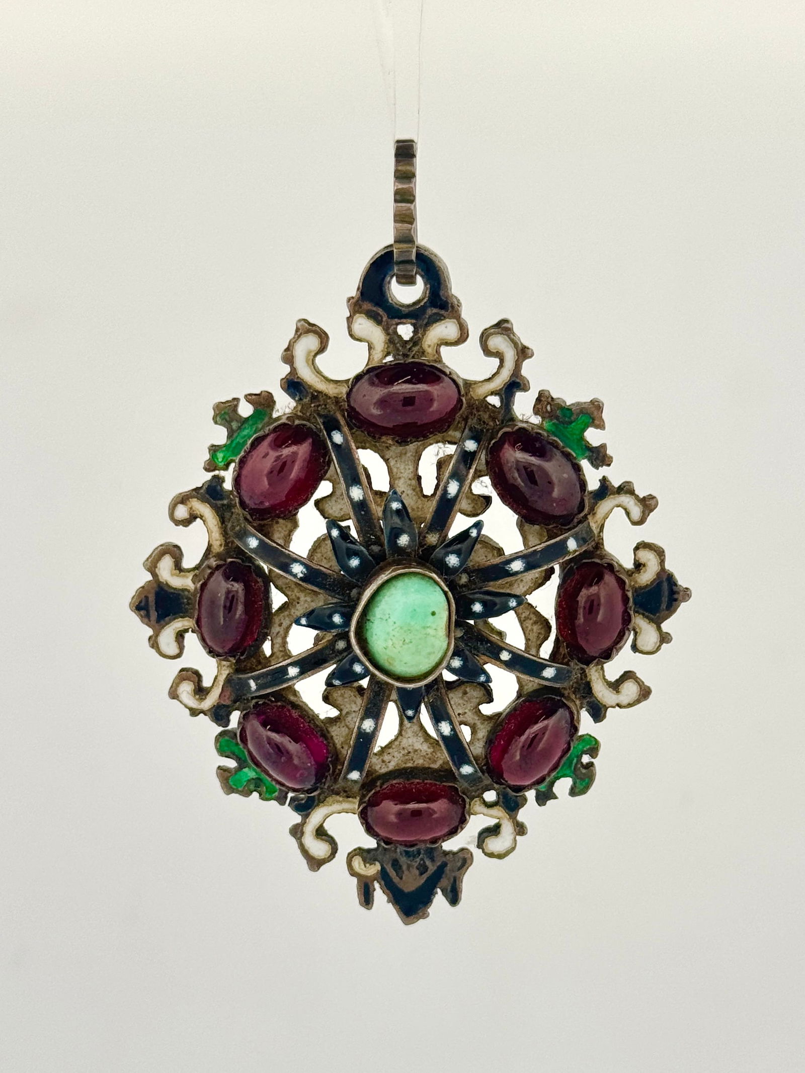 Austro-Hungarian Silver Enamel Garnet & Turquoise Pendant: Vintage silver tone pendant featuring garnet-colored stones and a central turquoise stone. Measures approximately 2 1/2 x 1 3/8 inches and weighs 30 grams.