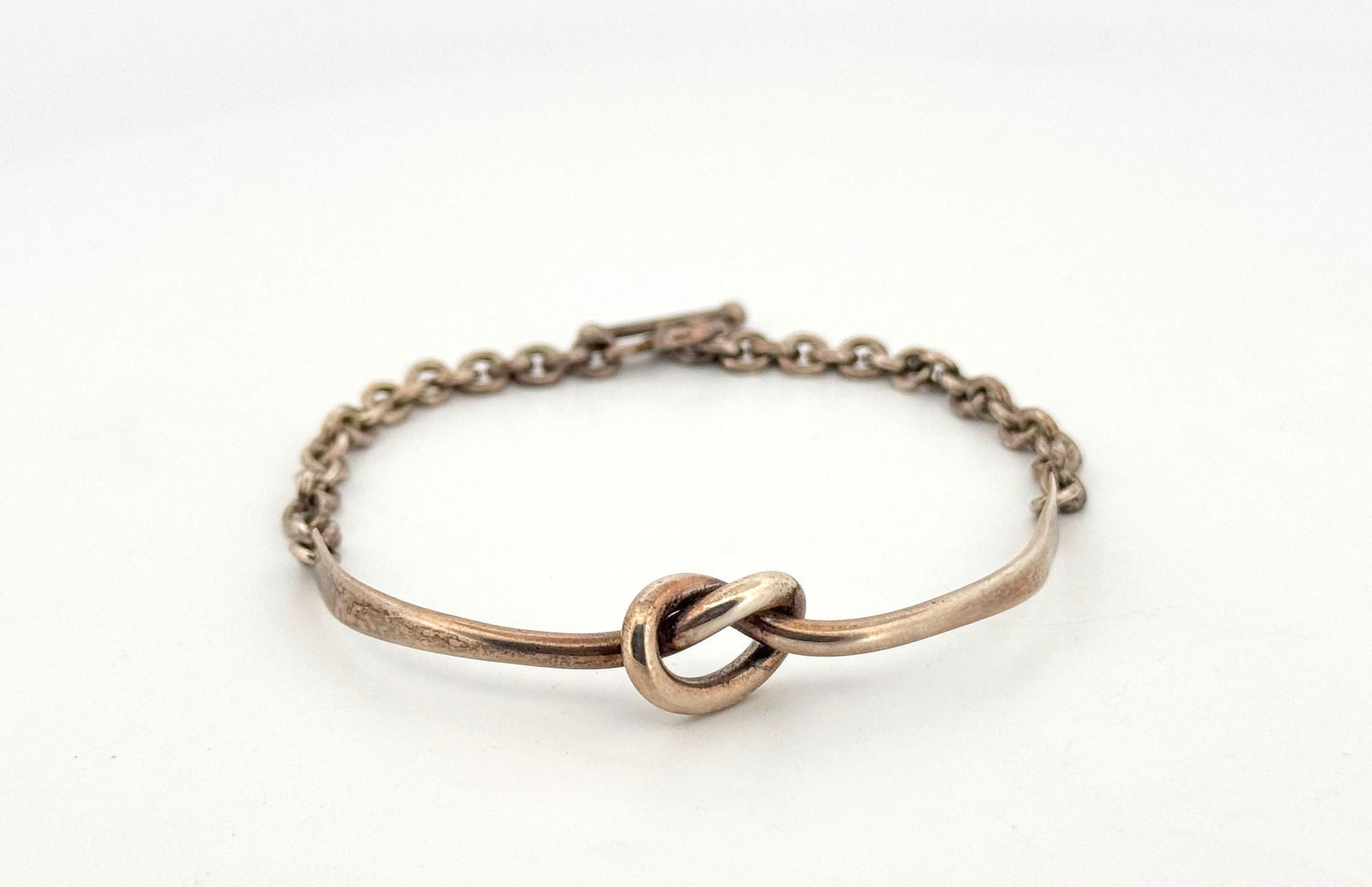 Georg Jensen Sterling Silver Knot Bracelet: Sterling silver bracelet featuring a love knot design. The bracelet has a toggle clasp and is marked '925'.9.2g