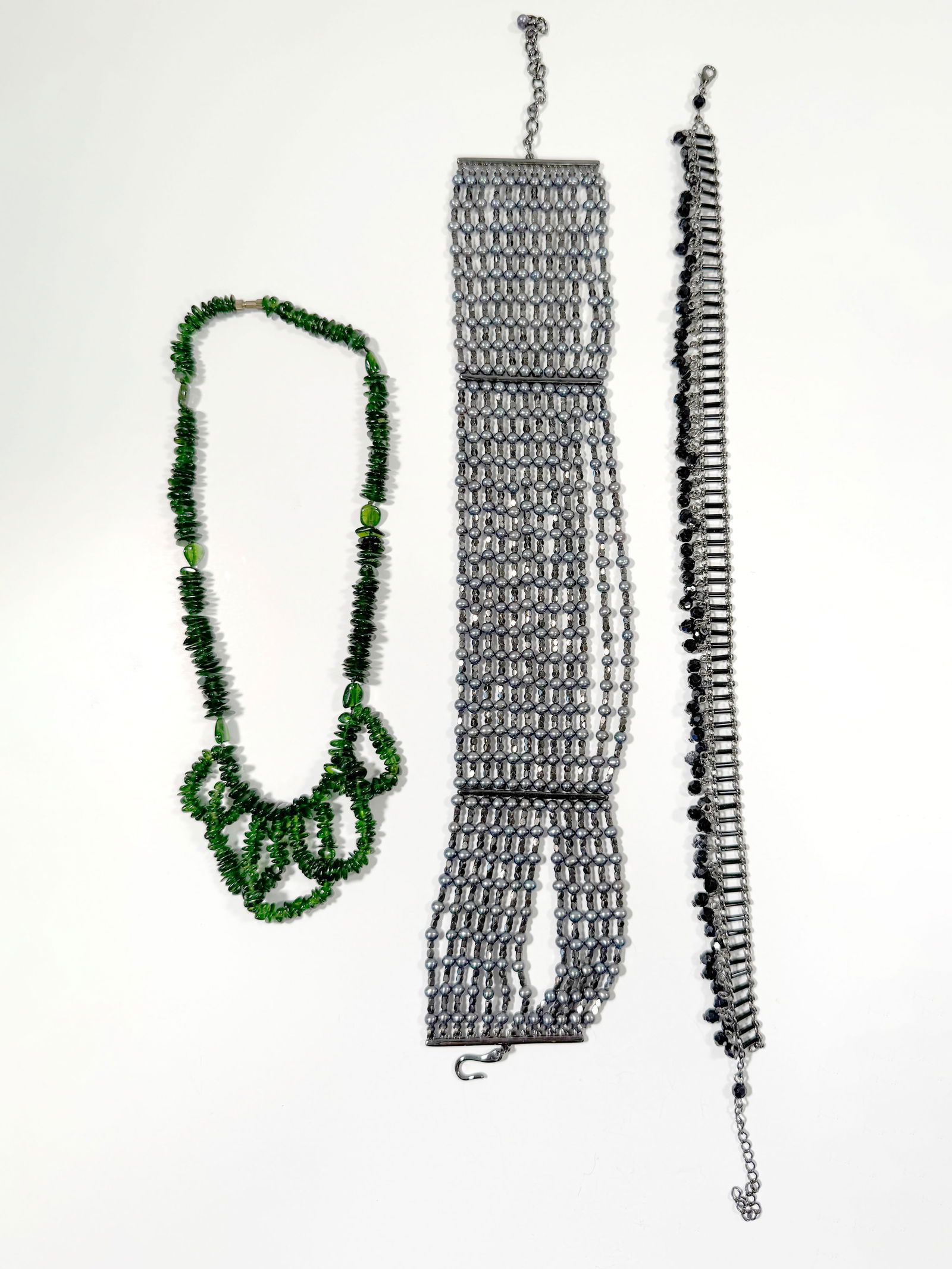 Three Costume Necklaces: Collection of three costume necklaces. Includes a green glass bead necklace, a multi-strand black bead necklace, and a black metal and bead necklace.Length : 14"201.5g