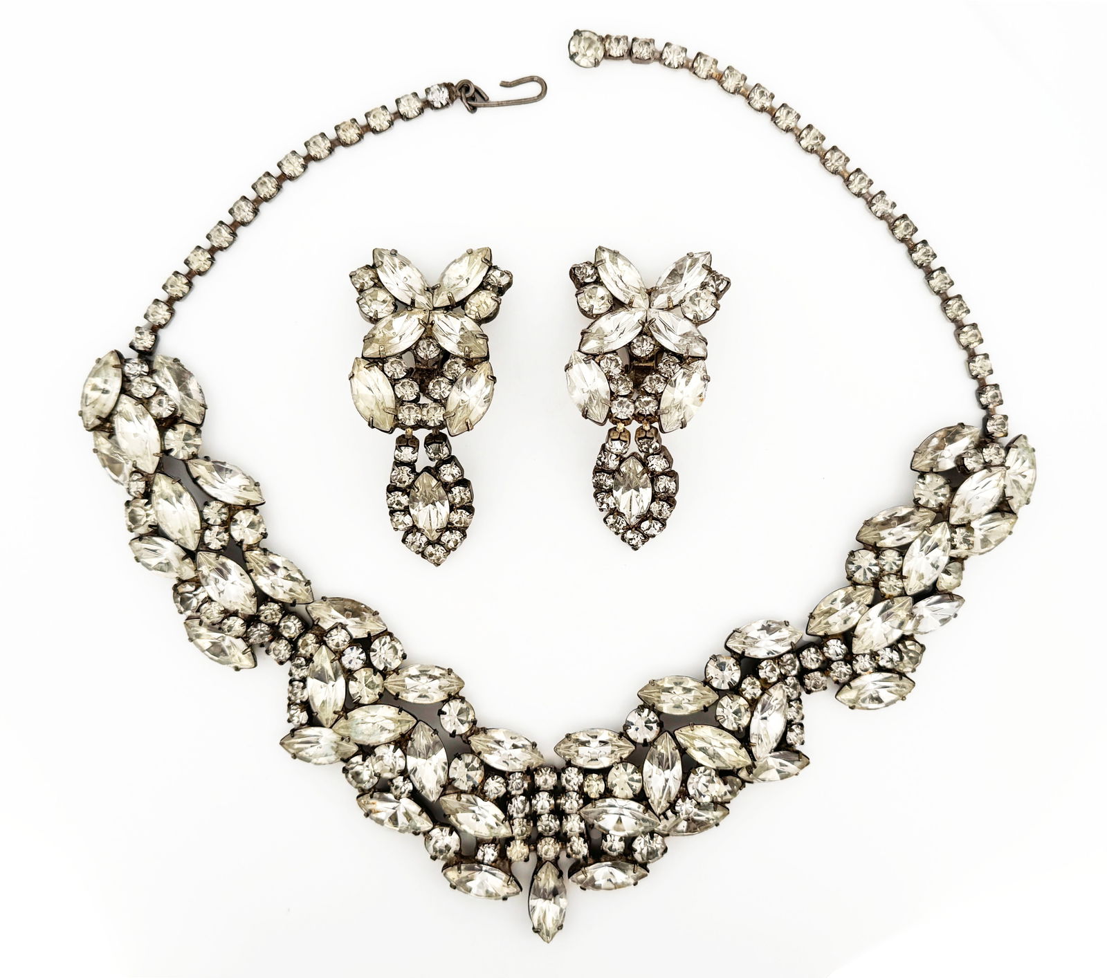 Rhinestone Necklace and Earring Set:  Rhinestone necklace and earring set featuring clear rhinestones in a floral design. Necklace is approximately 16.75 inches long, earrings are clip-on and approximately 2.38 inches long. Total