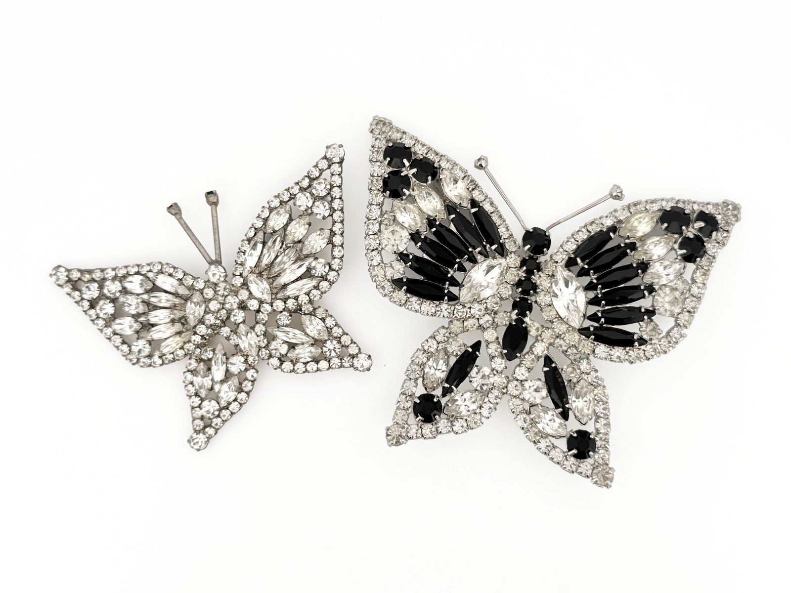 Two Rhinestone Butterfly Brooches: Two butterfly brooches with clear and black rhinestones. The larger brooch measures approximately 2.25" x 3"Total weight is 57.7g.