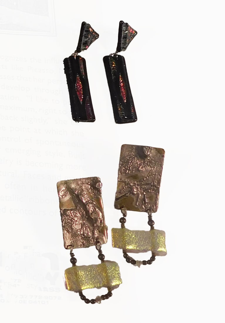 Earrings by Yvonne Buijs: Two pairs of earrings by Yvonne Buijs for Stein Gallery. One pair features a rectangular metal piece with an iridescent glass accent and bead detail. The other pair has a black rectangular piece with