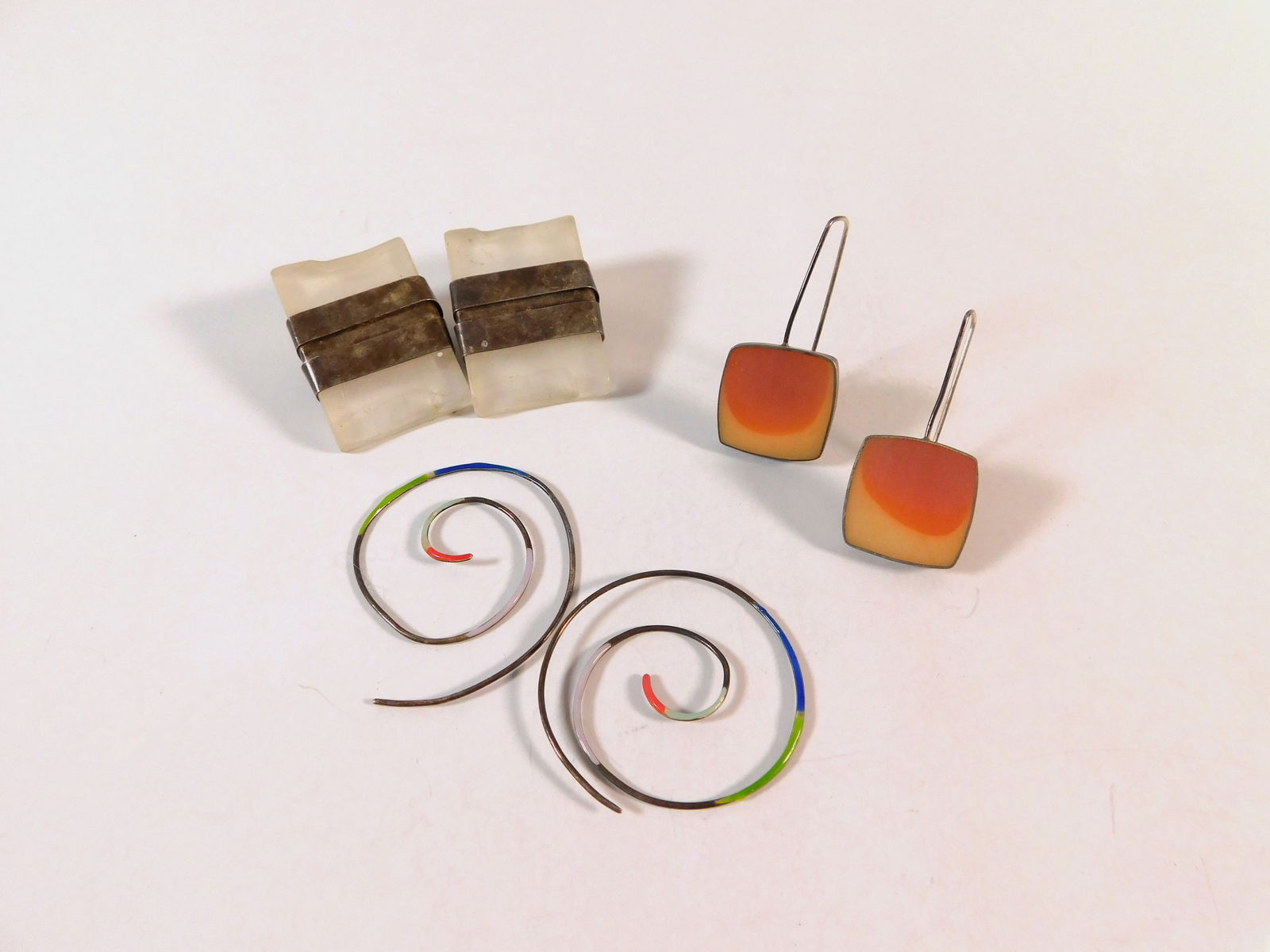 Three Pairs of Art Earrings: Three pairs of fashion earrings. One pair is a square drop earring, one is a square stud earring, and the third is a spiral drop earring. Weight: 36.9g