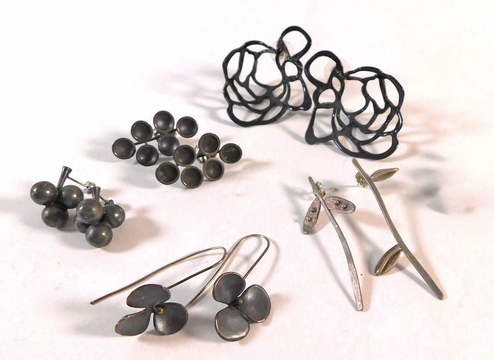 Five Pairs of Mixed Metal Earrings: A collection of costume earrings featuring various designs including floral, geometric, and botanical motifs. Metal construction, some with black finish. Total weight: 53.9g