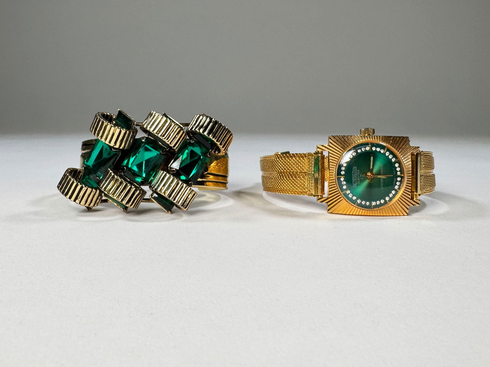 Vintage Remington Watch & Emerald Green Stone Bracelet: A Remington Electra 17 jewel watch with green face and gold tone band, along with a gold tone bracelet featuring emerald green stones. Watch widest part: 1.25''. Bracelet widest part: