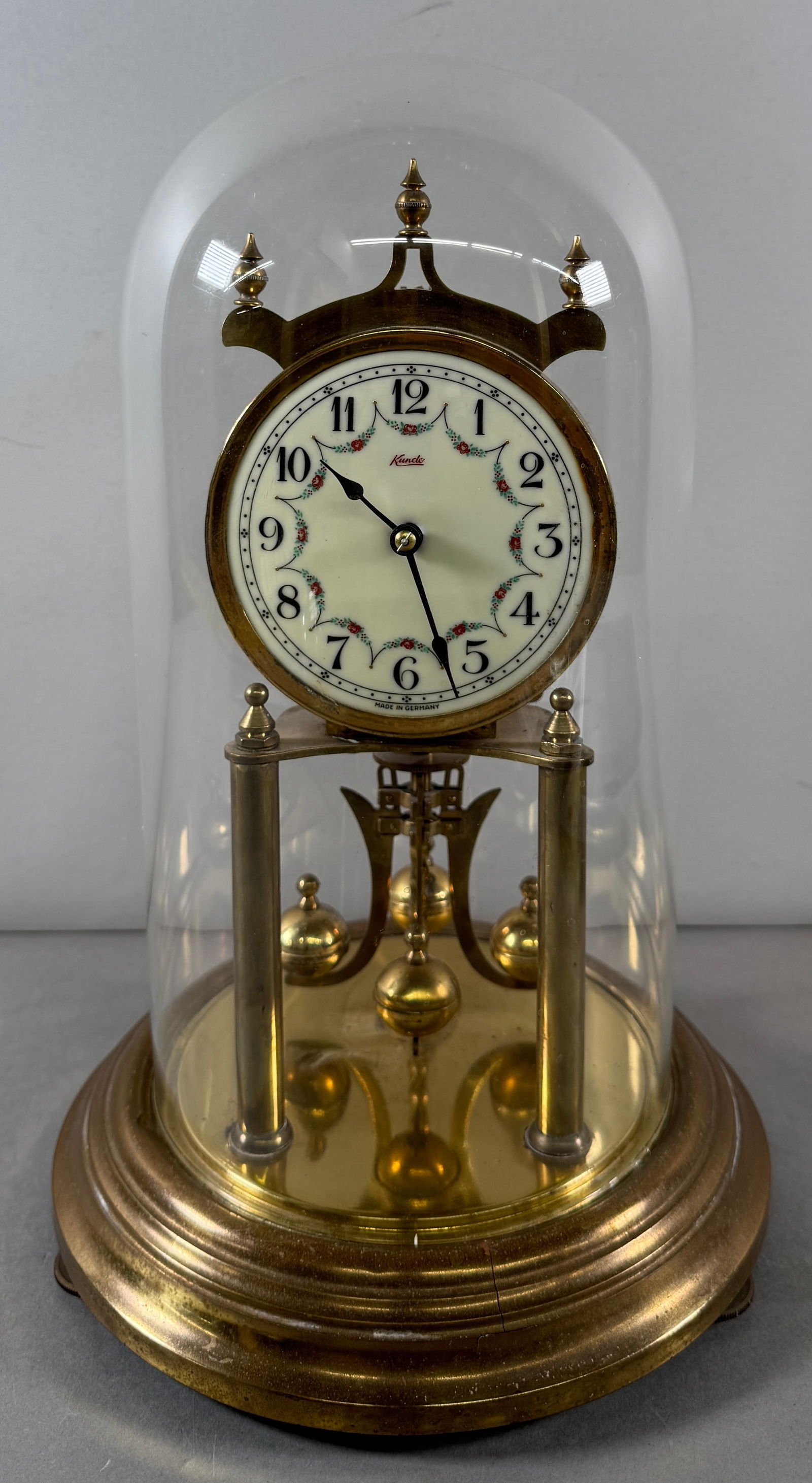 Kundo Anniversary Clock with Glass Dome: Kundo Anniversary Clock with glass dome and torsion pendulum. Dimensions: 11.5 x 6 inches. Weight: 62 oz. A beautiful timepiece for any collection.