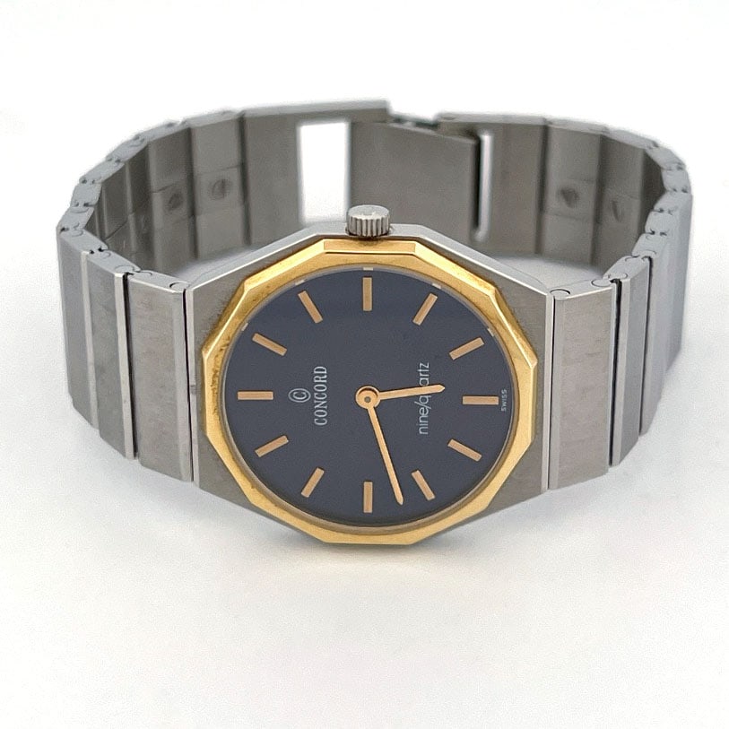 Concord Mariner SG 18K Bezel Quartz Wristwatch, REF 15.91.145: Concord Mariner SG quartz wristwatch Reference 15.91.145. Features a stainless steel case with a 18k gold bezel, a dark blue dial with gold-tone hands and markers, and a stainless steel integrate