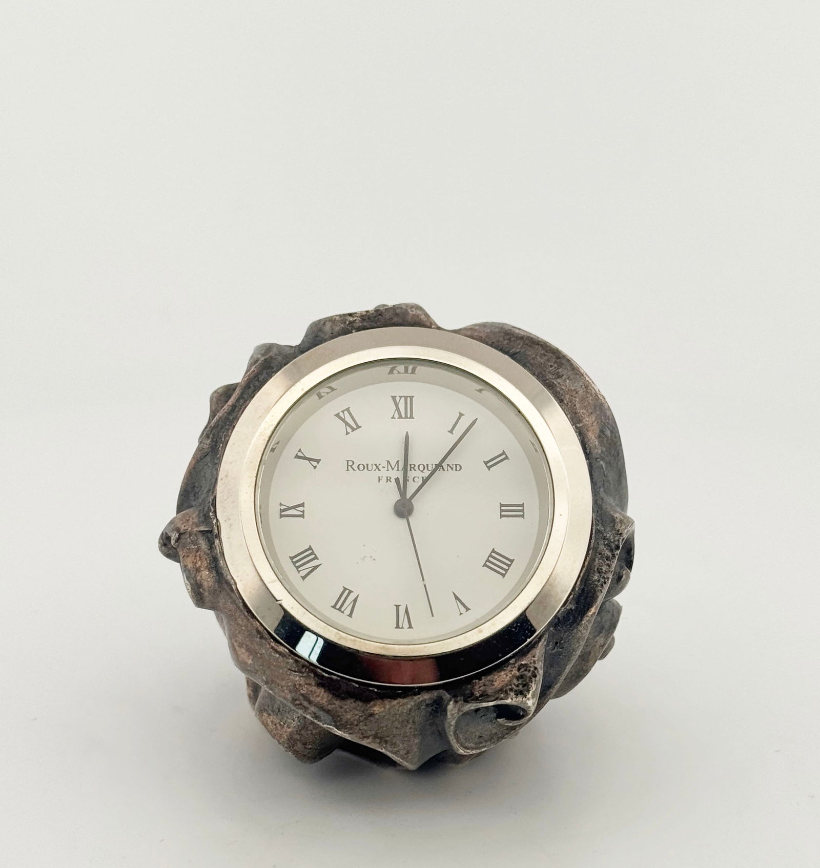 Roux-Marquand Paris Desk Clock, Perkins 3110-43: Roux-Marquand Paris desk clock featuring a silver-tone case with ornate detailing and a white face with Roman numeral markers. Measures approximately 2" x 2.75".