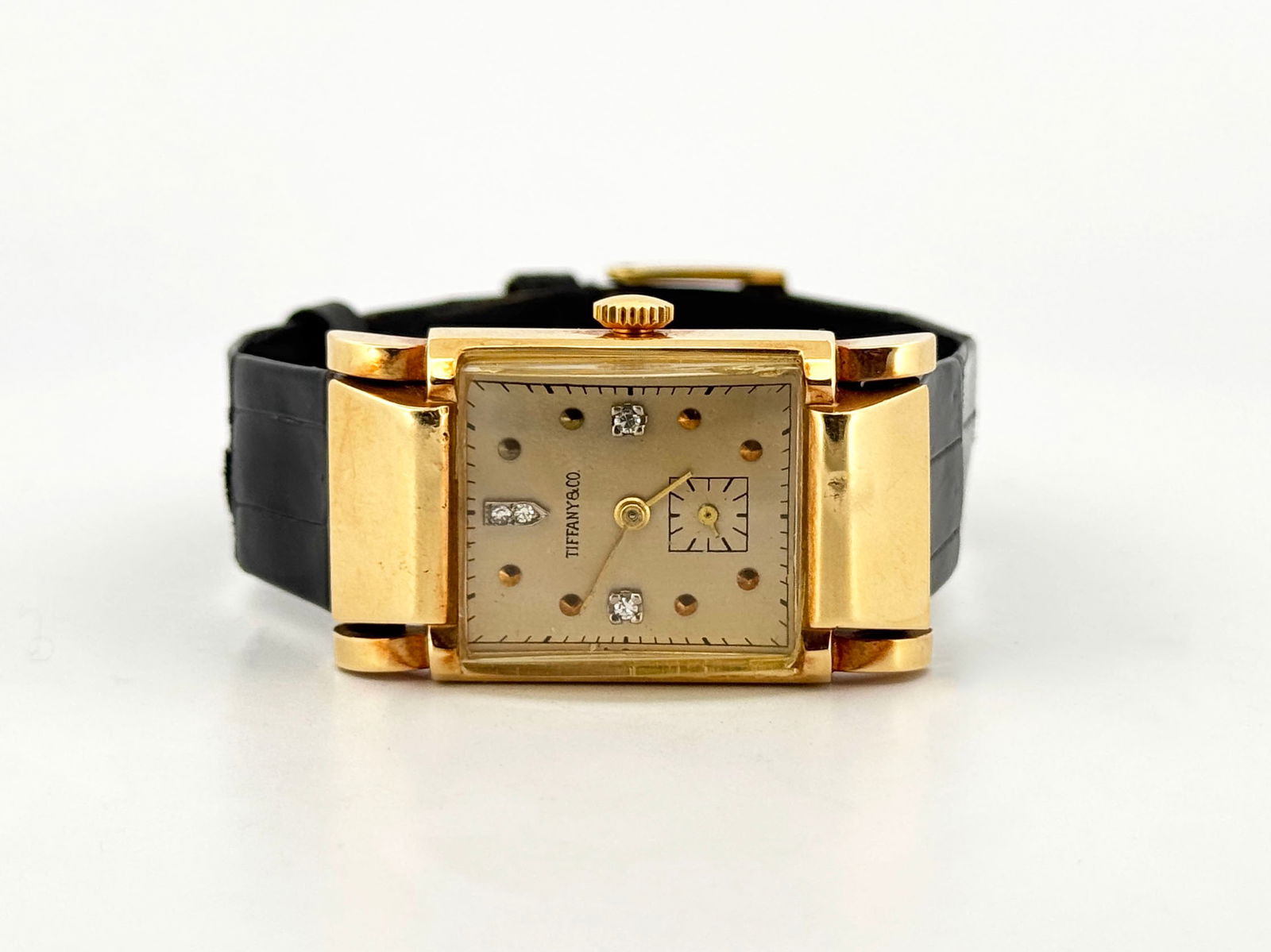 Tiffany & Co. 14k Gold & Diamond Wristwatch: Tiffany & Co. wristwatch. Features a gold-tone case with diamond accents on the dial and a black leather band. The watch face is marked Tiffany & Co.