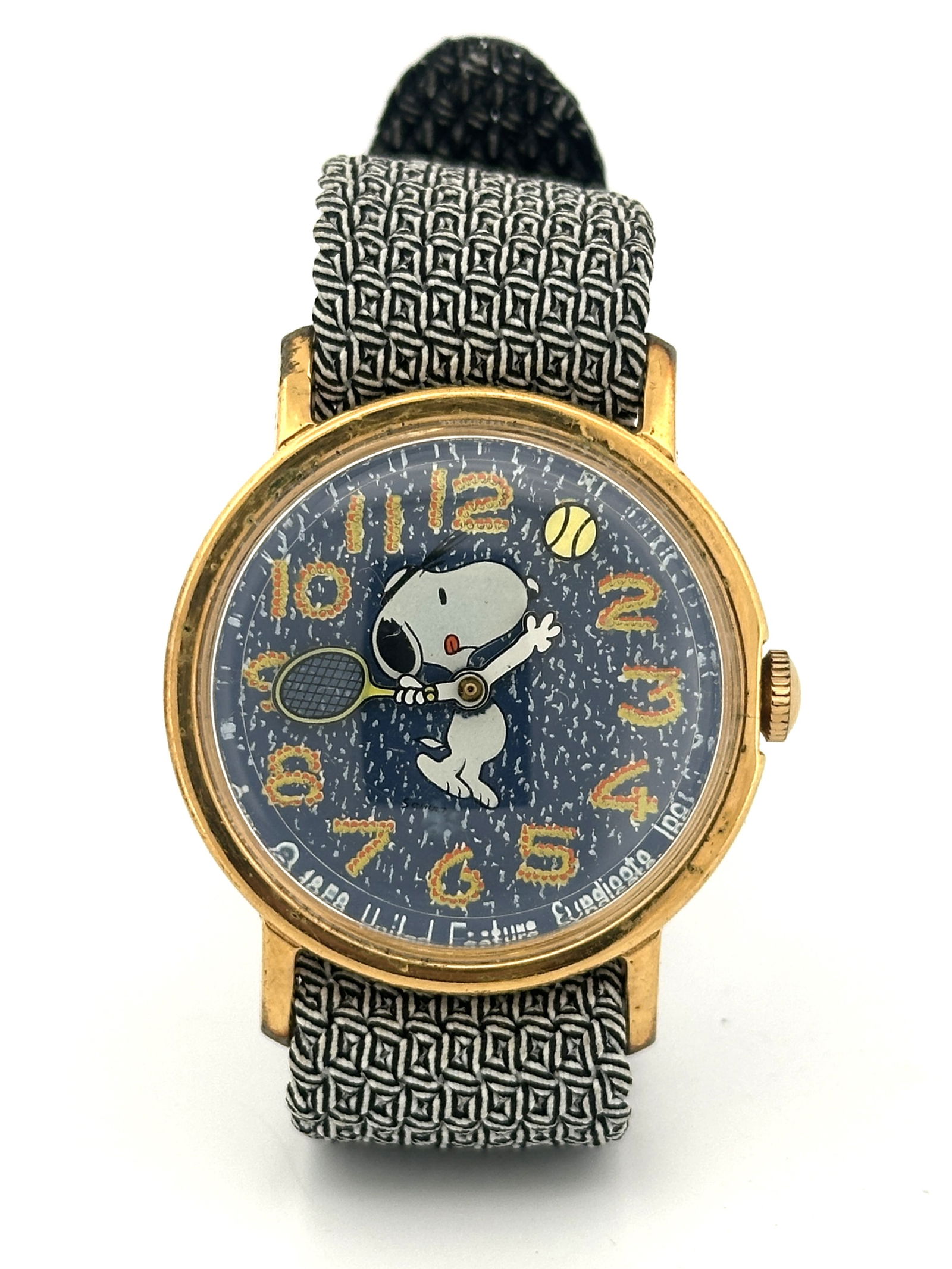 Vintage Snoopy Tennis Mechanical Wristwatch: Vintage Snoopy mechanical wristwatch featuring Snoopy playing tennis on the dial. The watch has a gold-tone case and a patterned band. The back is stainless steel. Base metal bezel.