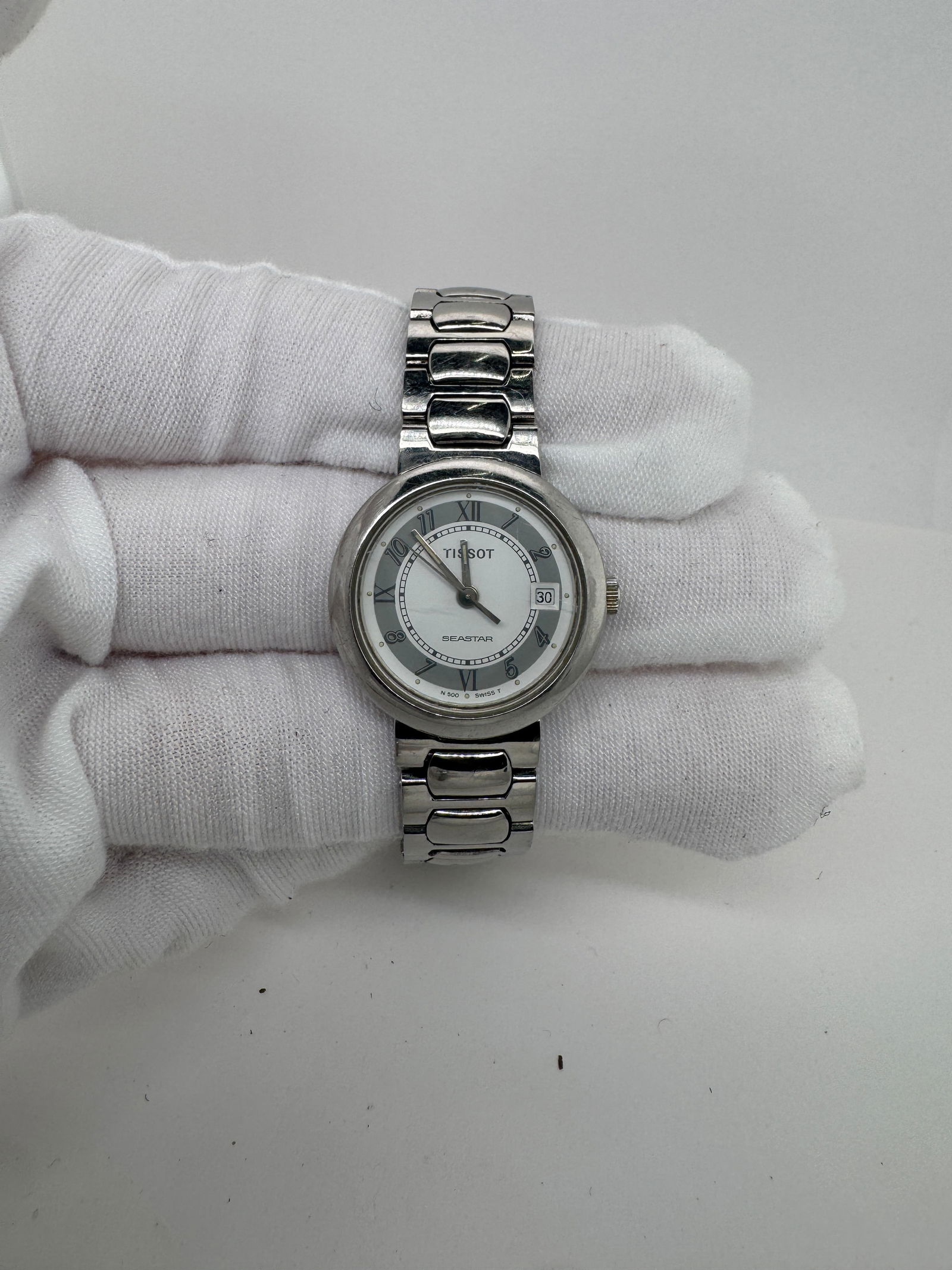 Tissot N500 Ladies' Quartz Wristwatch: Ladies' wristwatch featuring a round case, white dial with Roman numeral markers, and a stainless steel bracelet. Quartz movement. Not running, needs battery.