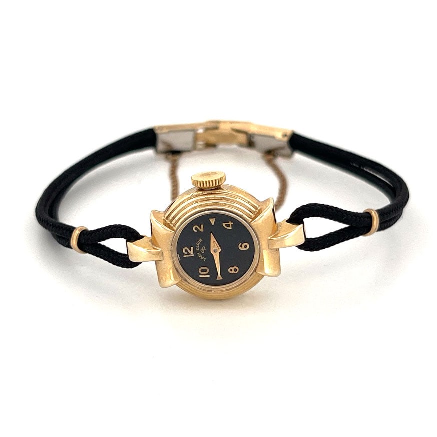 Lady Elgin 14K Gold Wristwatch with Cord Band: Lady Elgin wristwatch with a 14K gold case and a black dial. The movement is marked Elgin USA 23 Jewels. The band is a black cord.