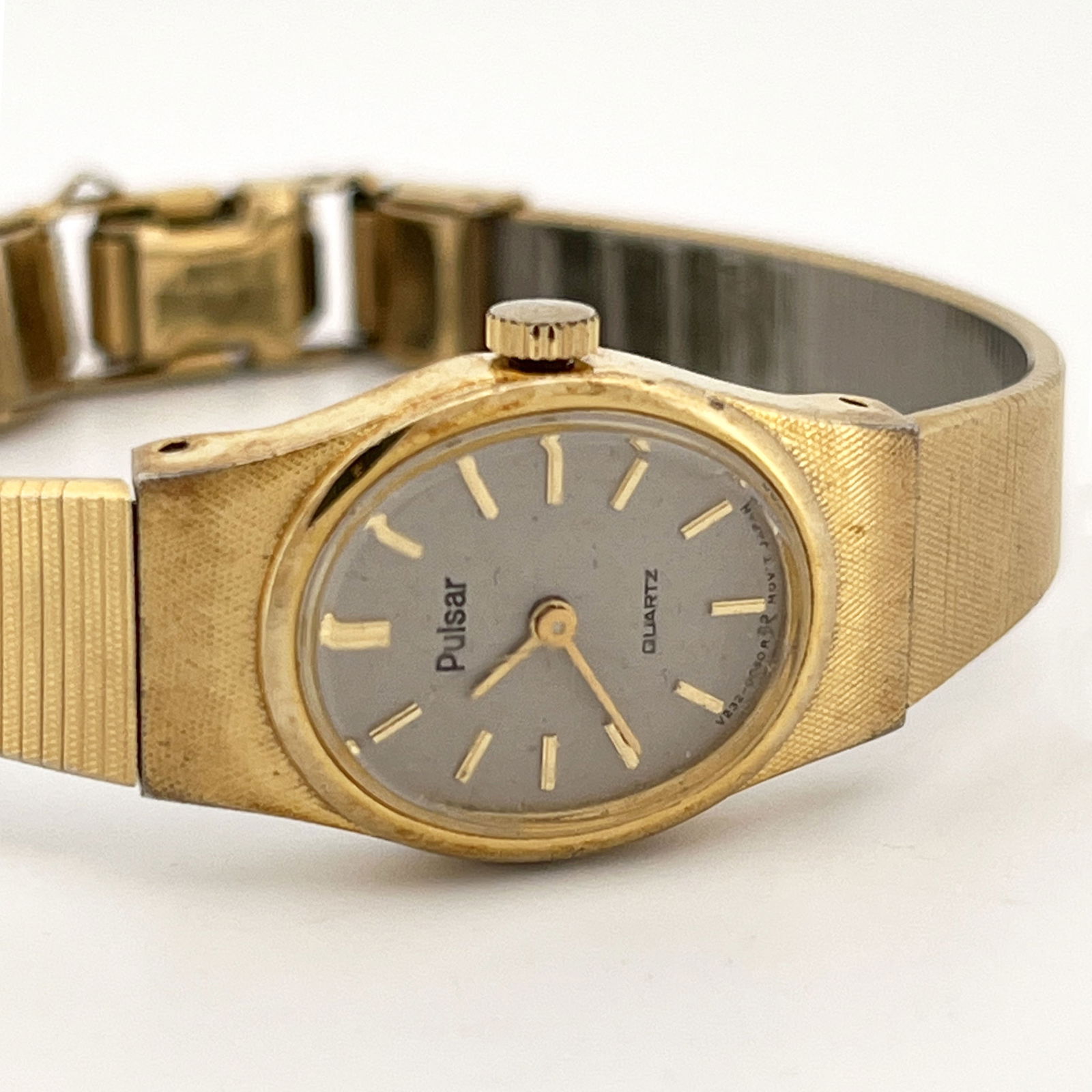 Ladies' Pulsar Quartz Wristwatch: Ladies' Pulsar quartz wristwatch with a gold-tone finish and a gray dial. The back is stainless steel. The band is an expansion band.