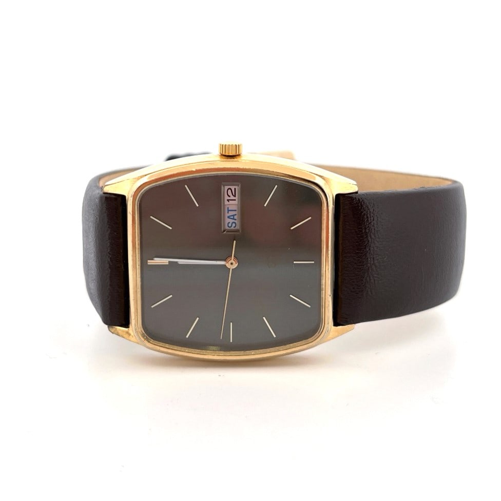 Seiko Quartz Day-Date Wristwatch, 2633-5029: Seiko quartz wristwatch with a gold tone case and brown leather strap. The black dial has gold baton indices and features a day-date complication powered by a caliber 2633 movement. The case back