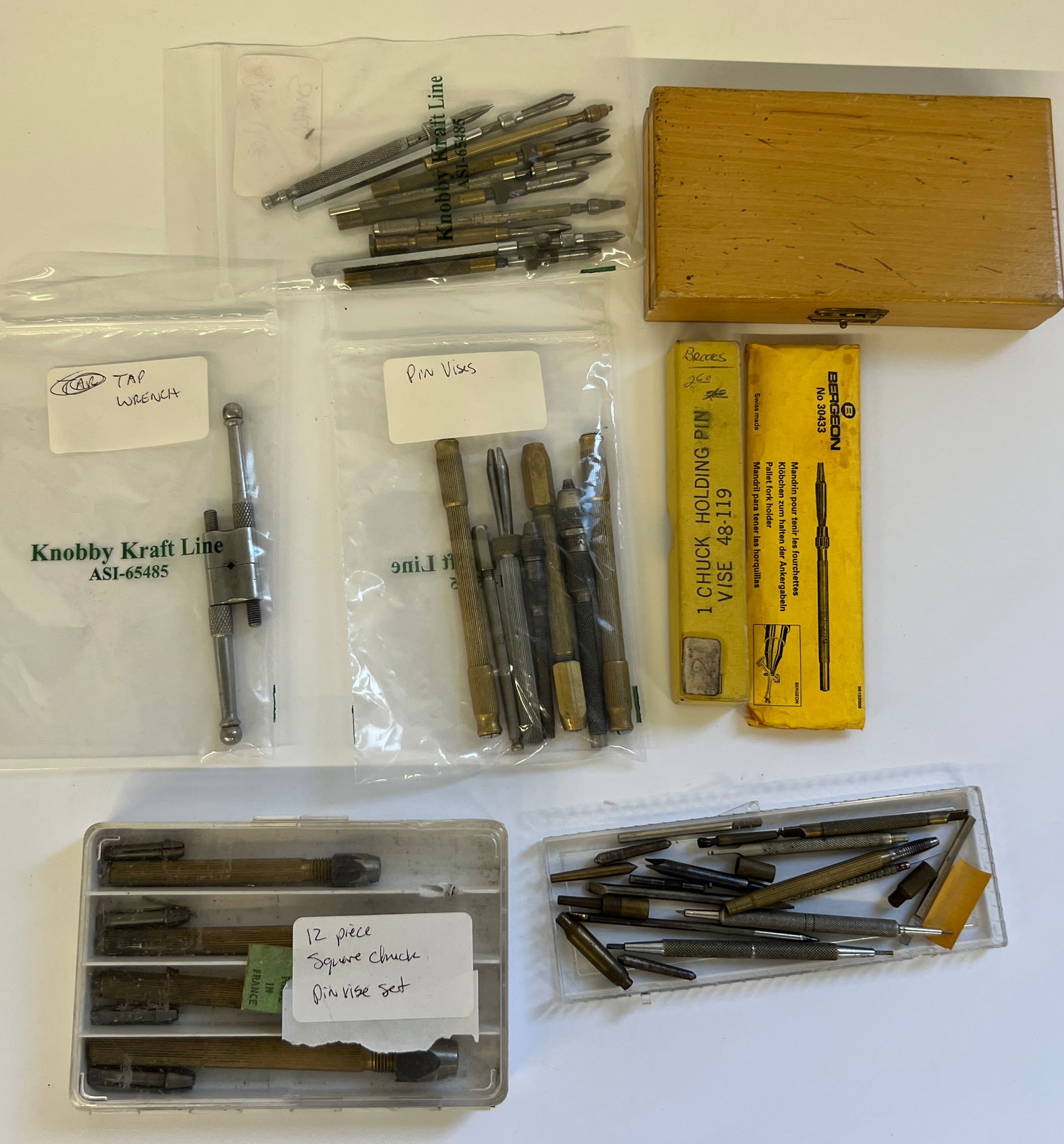Watch Repair Tools: Pin Vises, Tap Wrench, Square Chucks: Collection of watch repair tools including pin vises, a tap wrench, and a 12-piece square chuck pin vise set. Includes a Bergeon chuck holding pin vise and a wooden storage box. Various sizes and