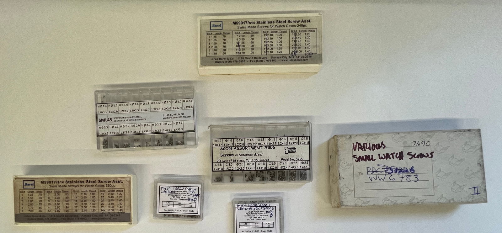 Assorted Watch Screws and Parts: Collection of assorted watch screws and small parts from J Borel and others. Includes various sizes and types, organized in labeled containers. A useful lot for watchmakers and repair professionals.