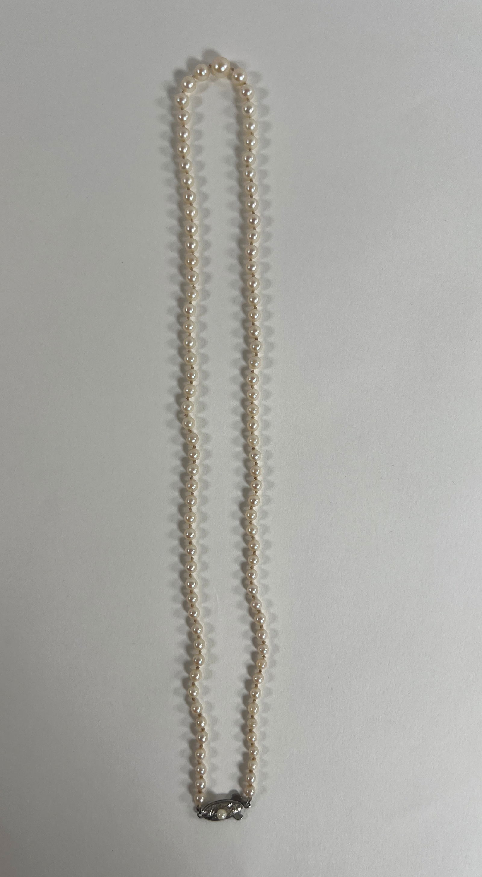 Vintage Pearl Necklace: Vintage pearl necklace, approximately 11 inches long when closed. Features a decorative silver clasp. Weight: 0.6 oz.