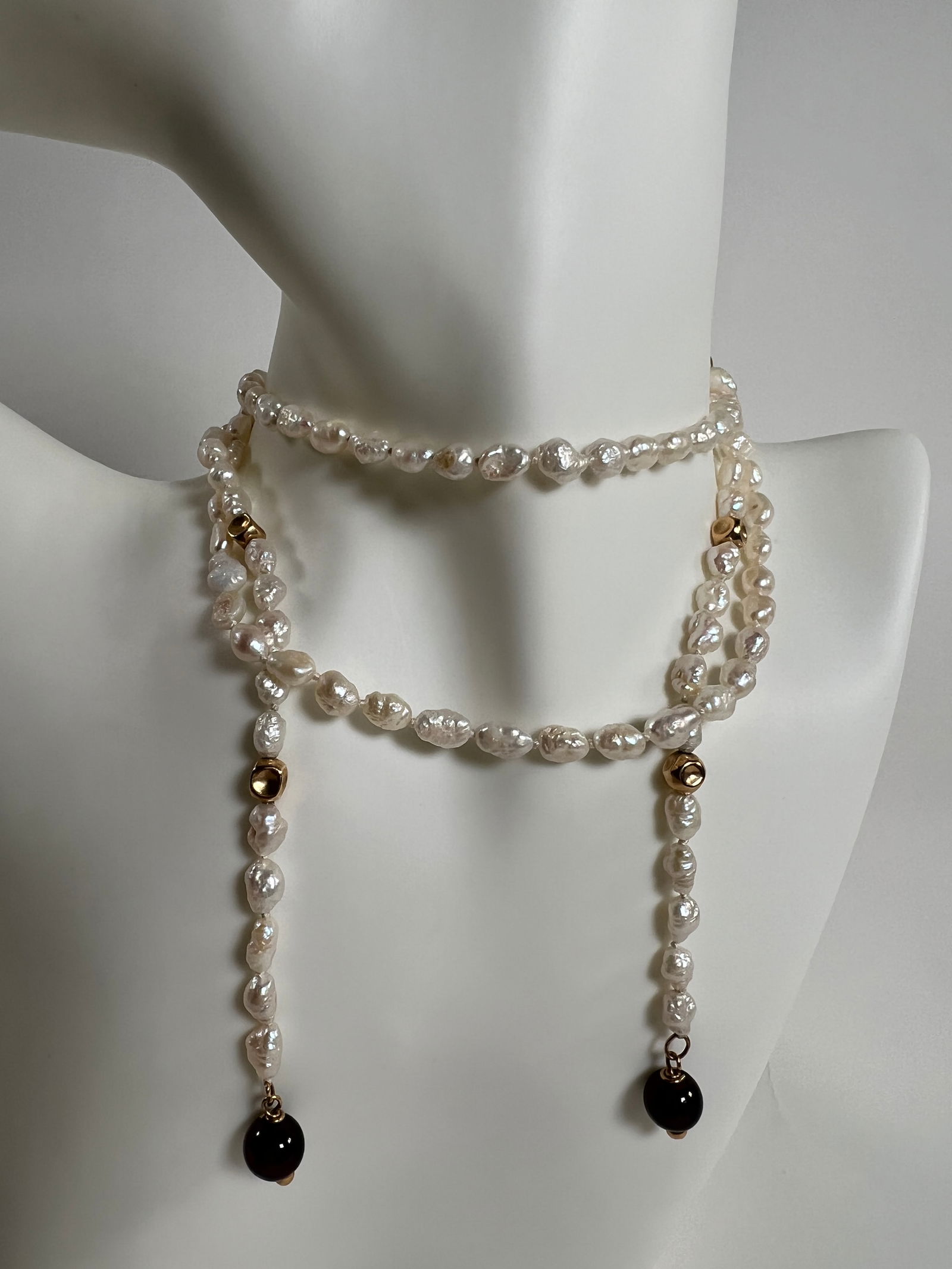 Freshwater Pearl Necklace with Gold and Black Beads: Freshwater pearl necklace featuring gold-tone and black beads. Measures 18.5 inches when closed. Weighs 0.9 oz.