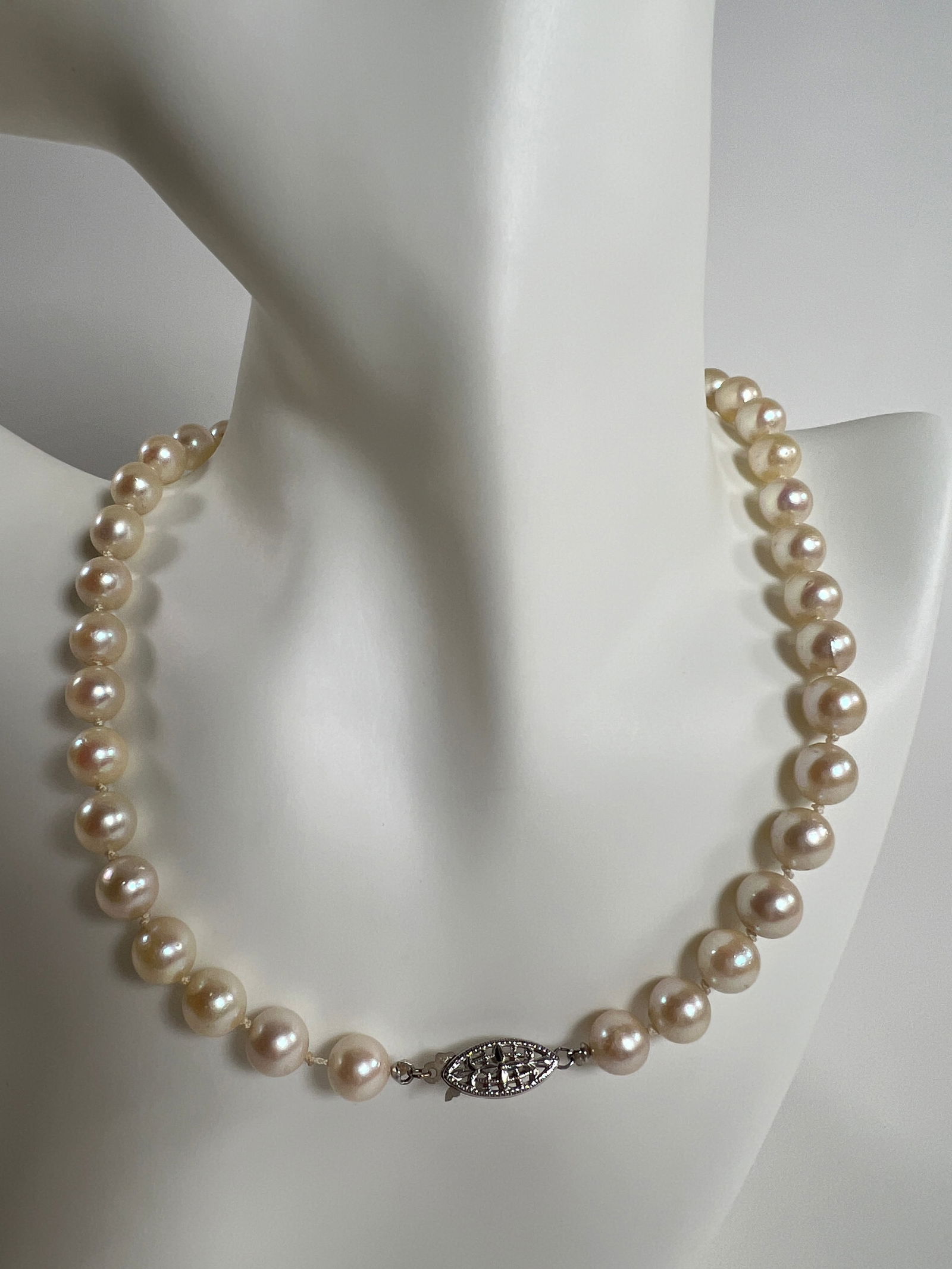 Pearl Necklace with Filigree Clasp: Elegant pearl necklace featuring a filigree clasp. Clasp is stamped as 14 karat gold. Measures 7.75 inches in length when closed, and weighs 1.2 oz. 
