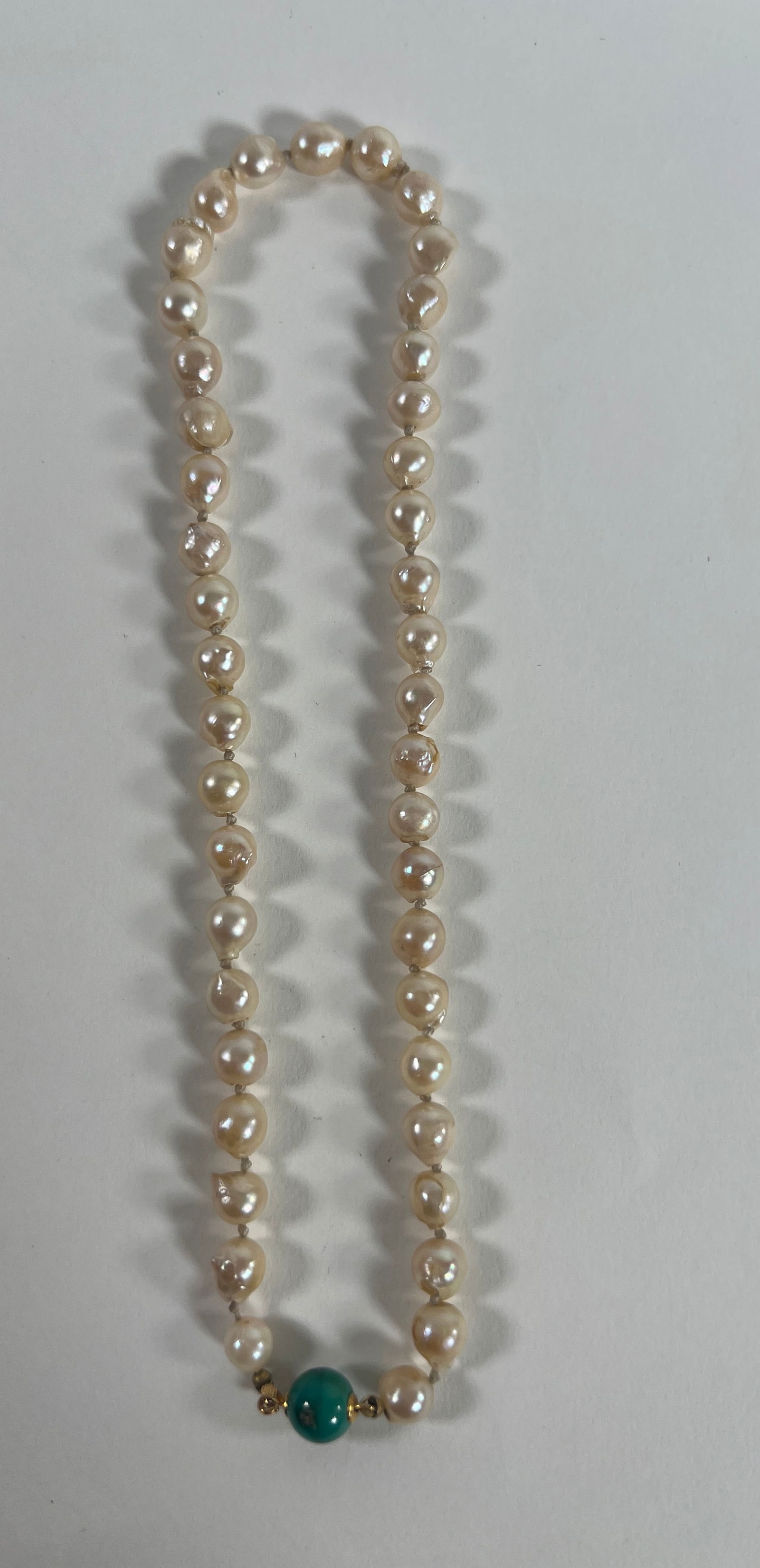 Pearl Necklace with Green Stone Clasp: A delicate pearl necklace featuring a single green stone clasp. The necklace measures approximately 7 inches in length when closed and weighs 0.8 oz.
