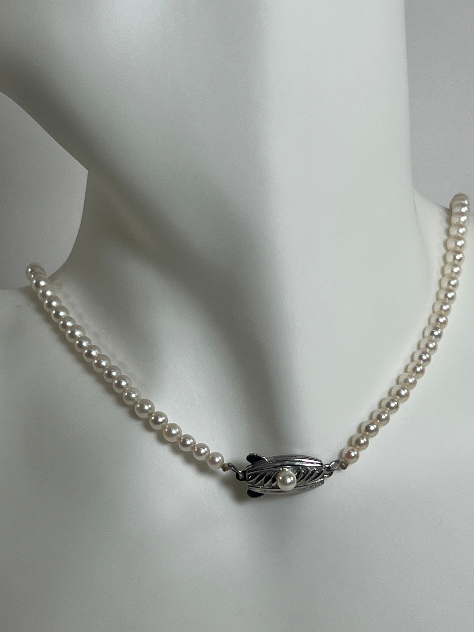 Vintage Pearl Necklace: Vintage pearl necklace, approximately 8.25 inches long when closed. Features a decorative clasp (silver). Weight: 0.6 oz.
