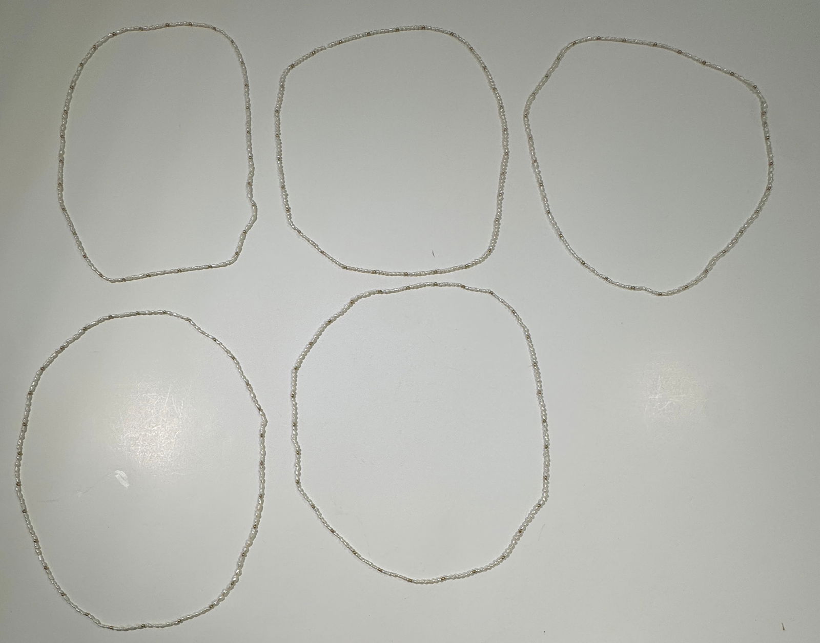 Freshwater Pearl and Gold Tone Bead Necklaces: A lot of 5 necklaces featuring freshwater pearls interspersed with gold-tone beads. The necklace has five strands of pearls and beads.Length : 17"