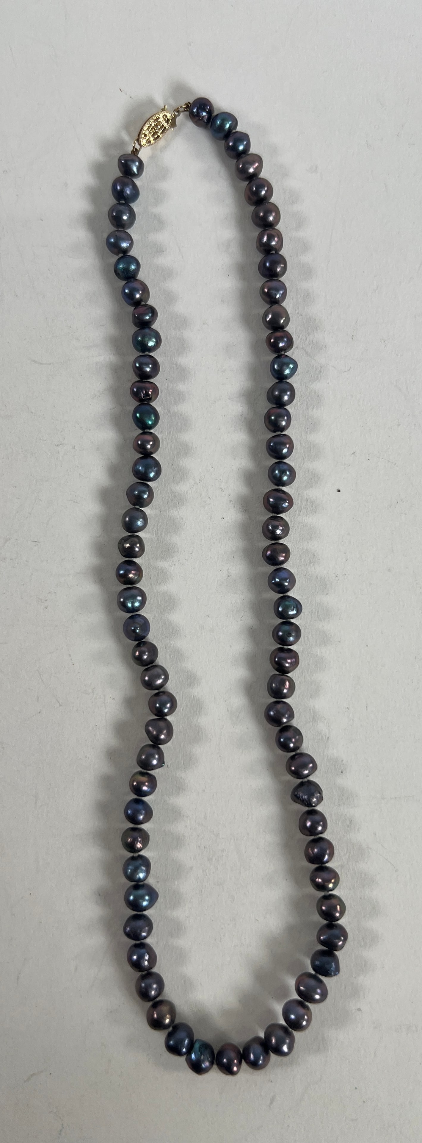 Black Pearl Necklace with Gold Clasp: Black pearl necklace featuring a 14 karat gold clasp. Measures 8.5 inches when closed and weighs 0.9 oz.