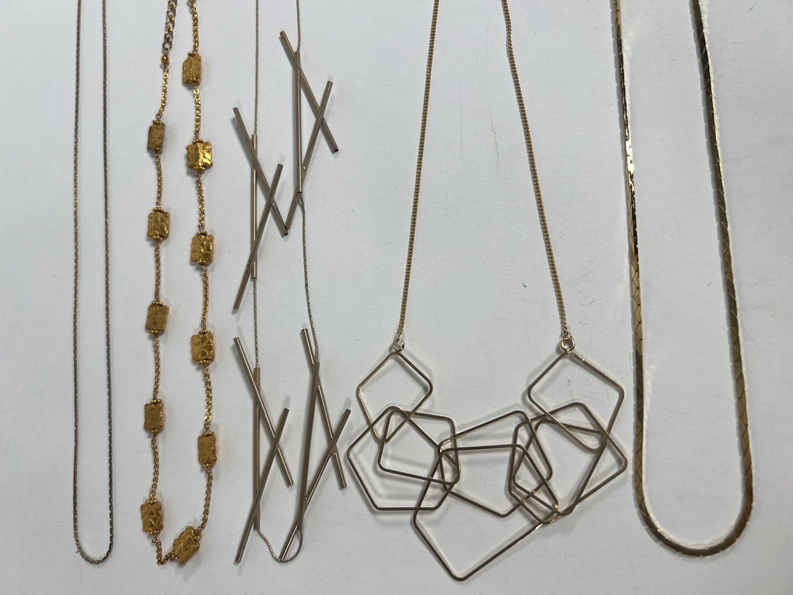 Group of Costume Necklaces: A group of five costume necklaces, ranging in length from 10 to 12 inches. Total weight is 1.4 oz. Includes various styles and designs.