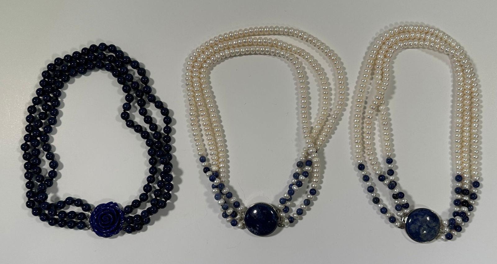 Three Beaded Necklaces with Lapis Accents: Three necklaces featuring beads and lapis accents. One necklace has dark blue beads with a carved lapis rose clasp. The other two have seed pearls and lapis beads with a lapis clasp. Largest is 9"