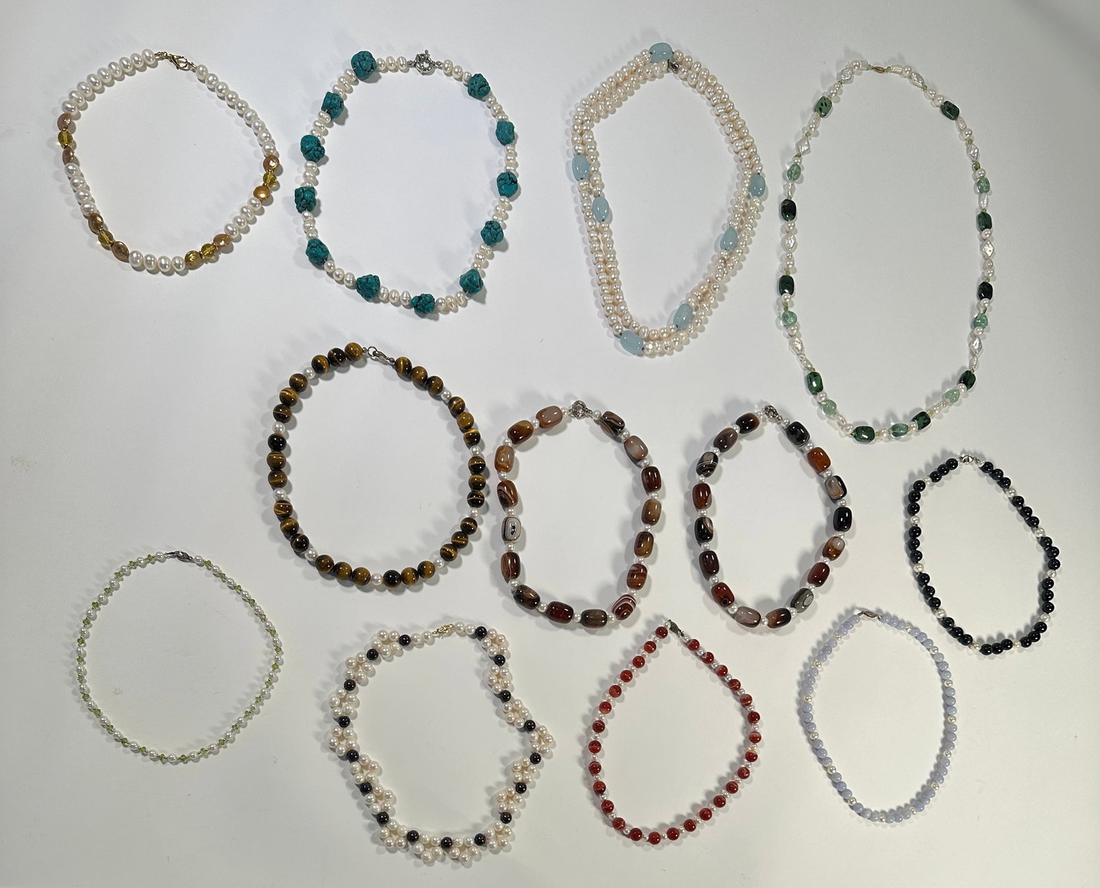 Collection of Beaded Necklaces (12): Collection of 12 beaded necklaces. Includes necklaces with pearls, turquoise, and various other stone beads. Many of the necklaces feature sterling silver filigree clasps. The longest neckla