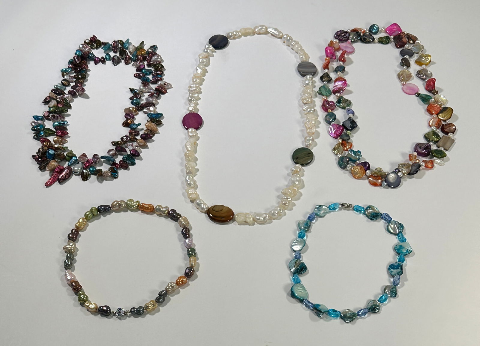 Five Beaded Necklaces with Pearls and Shells: Collection of five beaded necklaces. Includes strands with pearls, shell pieces, and colorful beads. The longest necklace measures approximately 26.5 inches.
