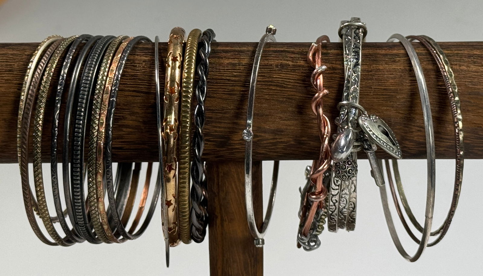Group of Assorted Metal Bangles: Collection of metal bangles. Various colors and styles, including some with charms. One bangle measures approximately 3 inches in diameter. Total weight 4.7 oz.