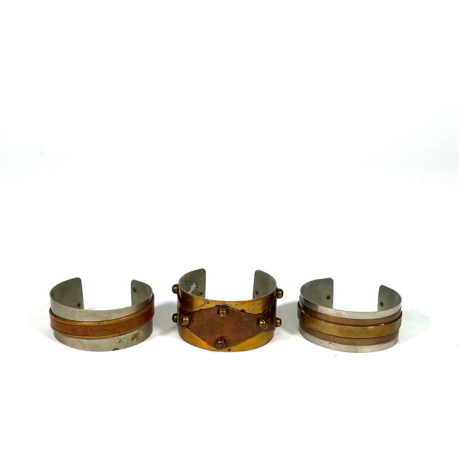 Lot of 3 Mixed Metal Cuff Bracelets: This lot features three cuff bracelets crafted from mixed metals. The designs include layered bands and decorative rivet accents.