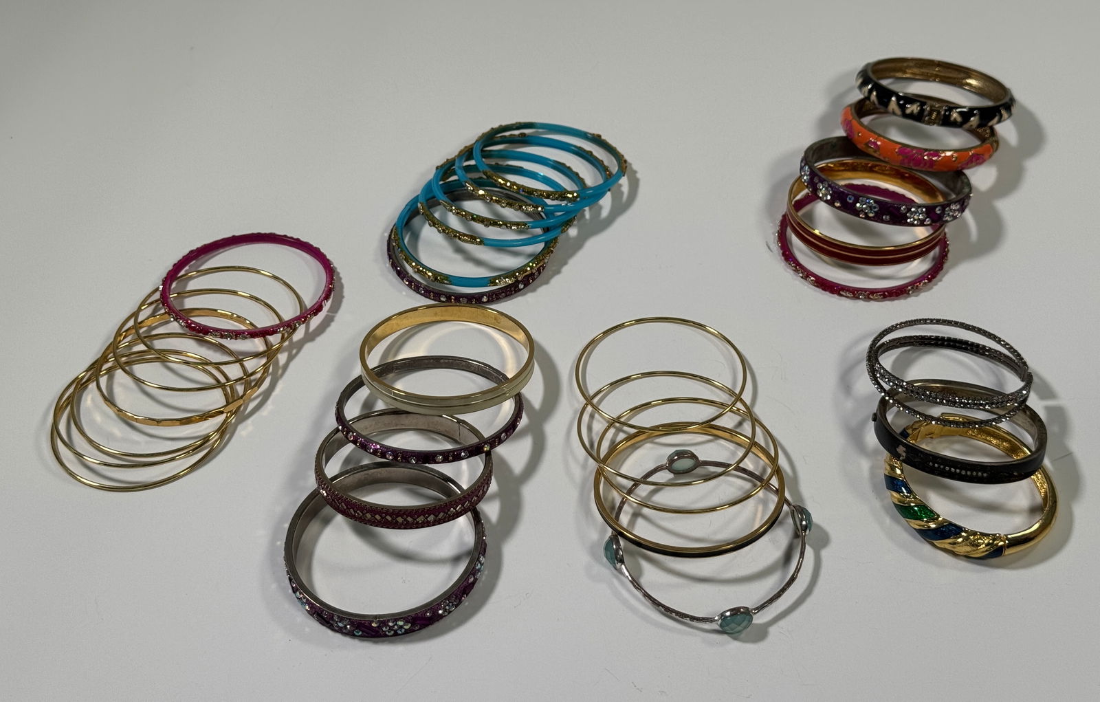 Monet Assorted Bangle Bracelet Collection (15+): Collection of over fifteen assorted bangle bracelets, including several marked 'Monet'. Styles include plain gold tone, colored enamel, and rhinestone embellished. Some wear may be present.
