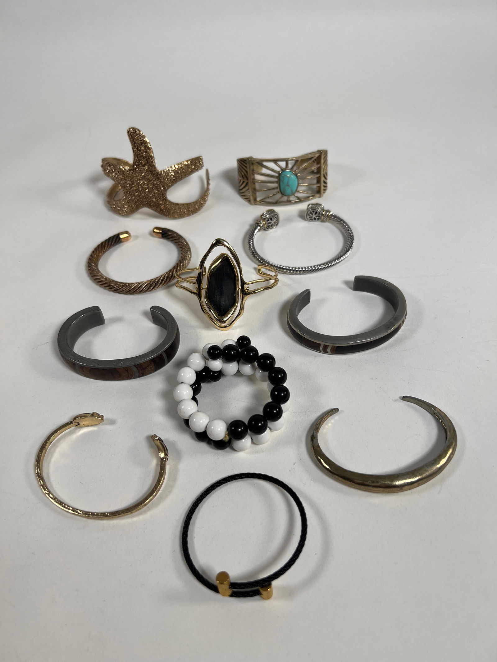 Group of Costume Bracelets - 11 Pieces: Eleven assorted costume bracelets, including cuff and bangle styles. Materials include metal, beads, and simulated stones. Largest measures approximately 3.5 x 2.5 inches. Total weight: 11.7 oz.