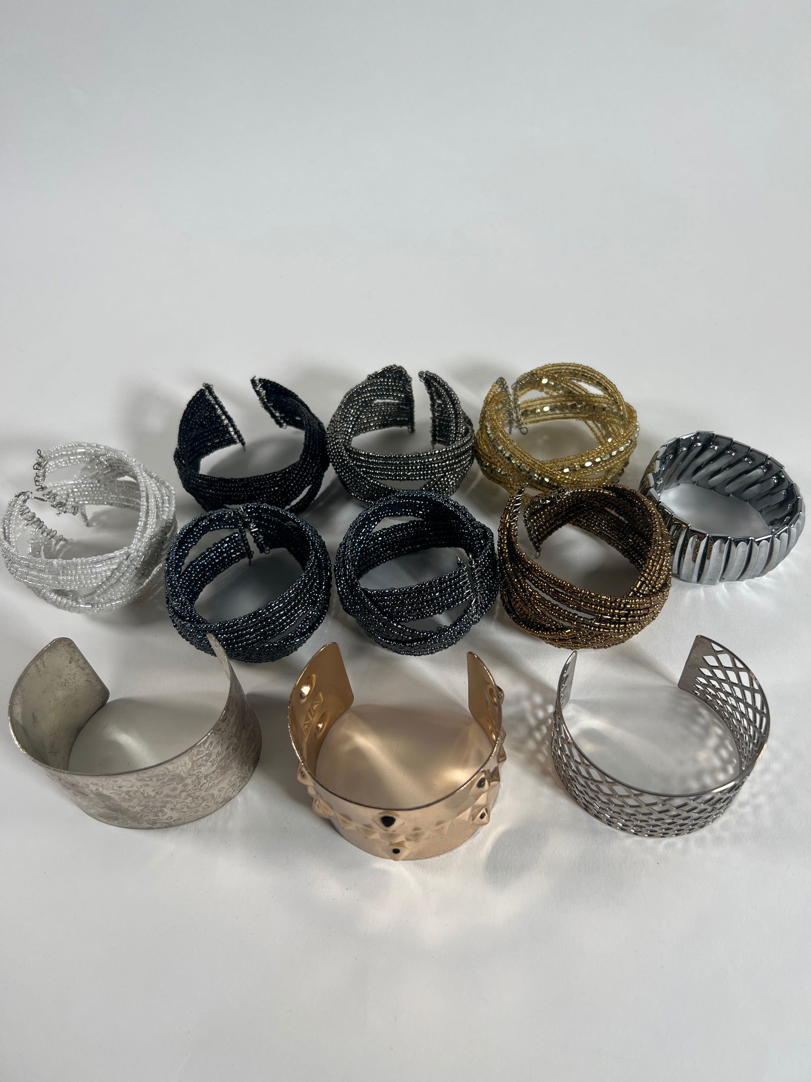 Collection of Costume Bracelets: Costume bracelets of varying styles and materials, including beaded, metal, and cuff designs. Sizes range from approximately 1.25 to 2.25 inches tall. Total weight: 15.3 oz.