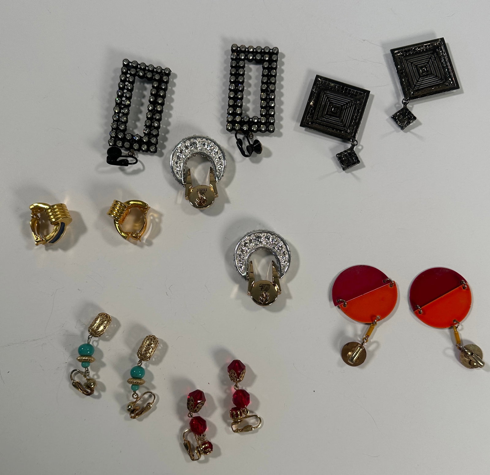 Assorted Costume Earrings: Collection of pairs of costume earrings. Styles include geometric shapes, rhinestone accents, and colorful beads. Sizes range from 1 to 2.75 inches. Total weight: 4.1 oz.