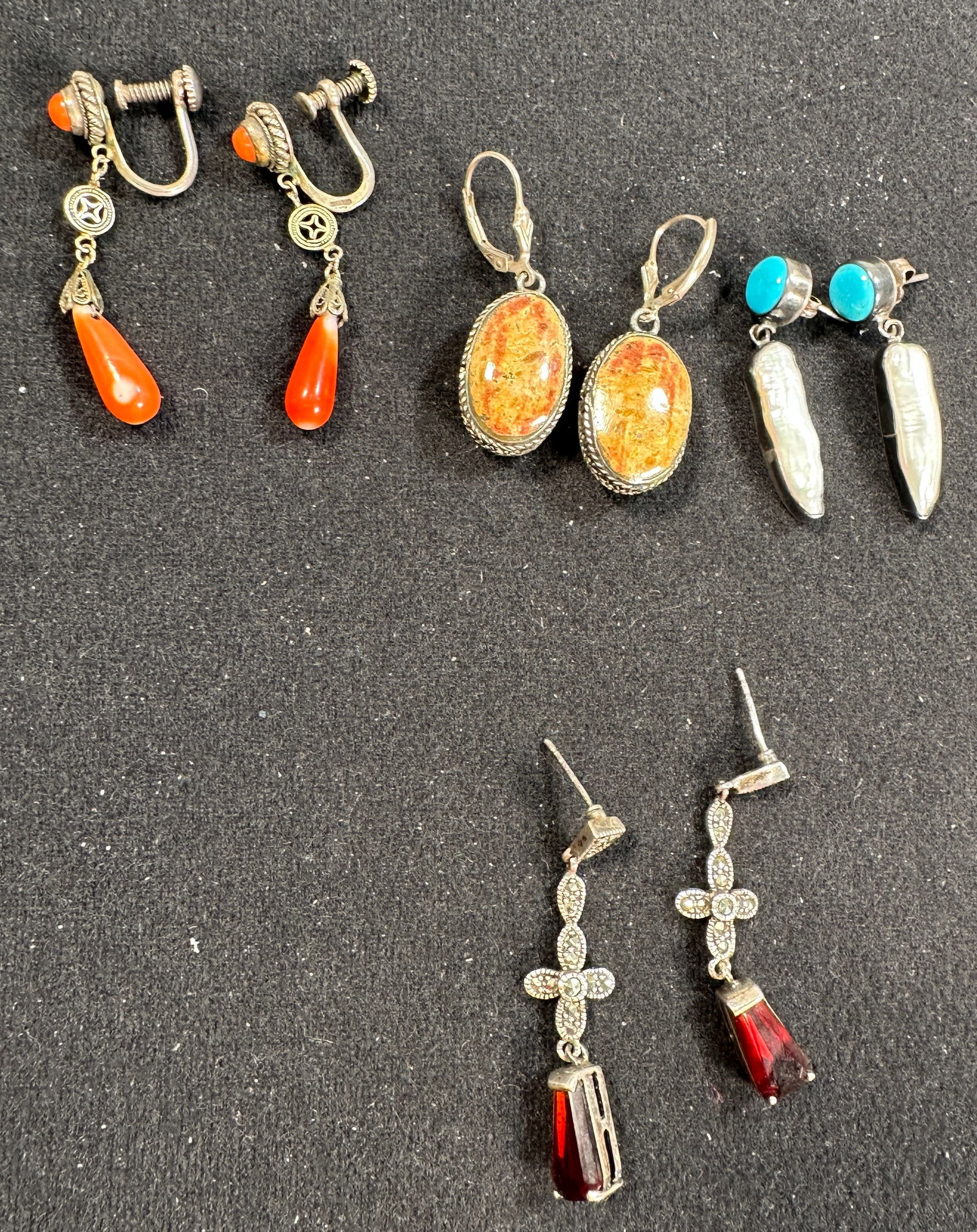 Sterling Silver & Stone Earring Assortment: A collection of 4 pairs of earrings, featuring sterling silver and various stones including coral, pearl, and garnet. The largest earring measures approximately 1.5 inches. Total weight is 1.1