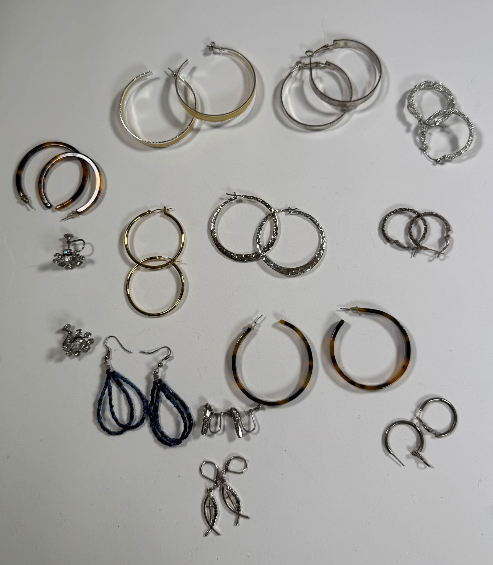 Assorted Costume Earrings: Collection of costume earrings, including hoops, studs, and dangles. Various styles and metal tones. Total weight: 2.8 oz.