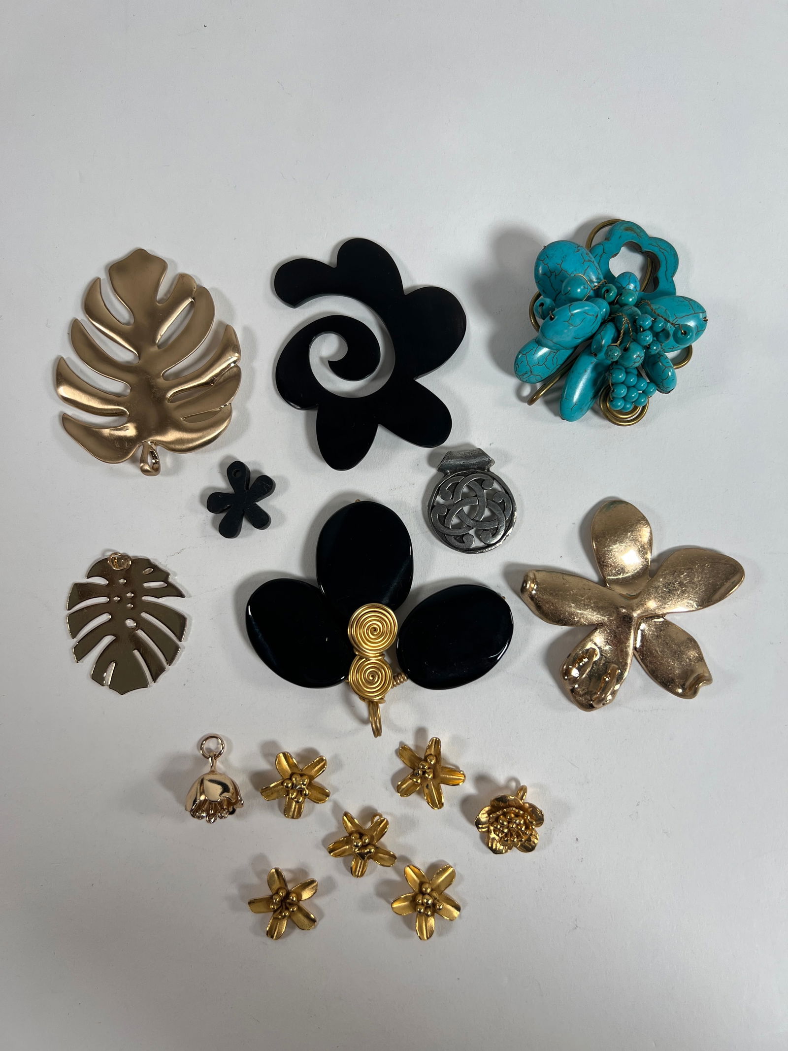Costume Jewelry Lot - Floral & Leaf Designs: Collection of costume jewelry pieces, including floral and leaf designs in gold, black, and turquoise colors. Sizes range from 0.75 to 3.25 inches. Total weight: 8 oz.