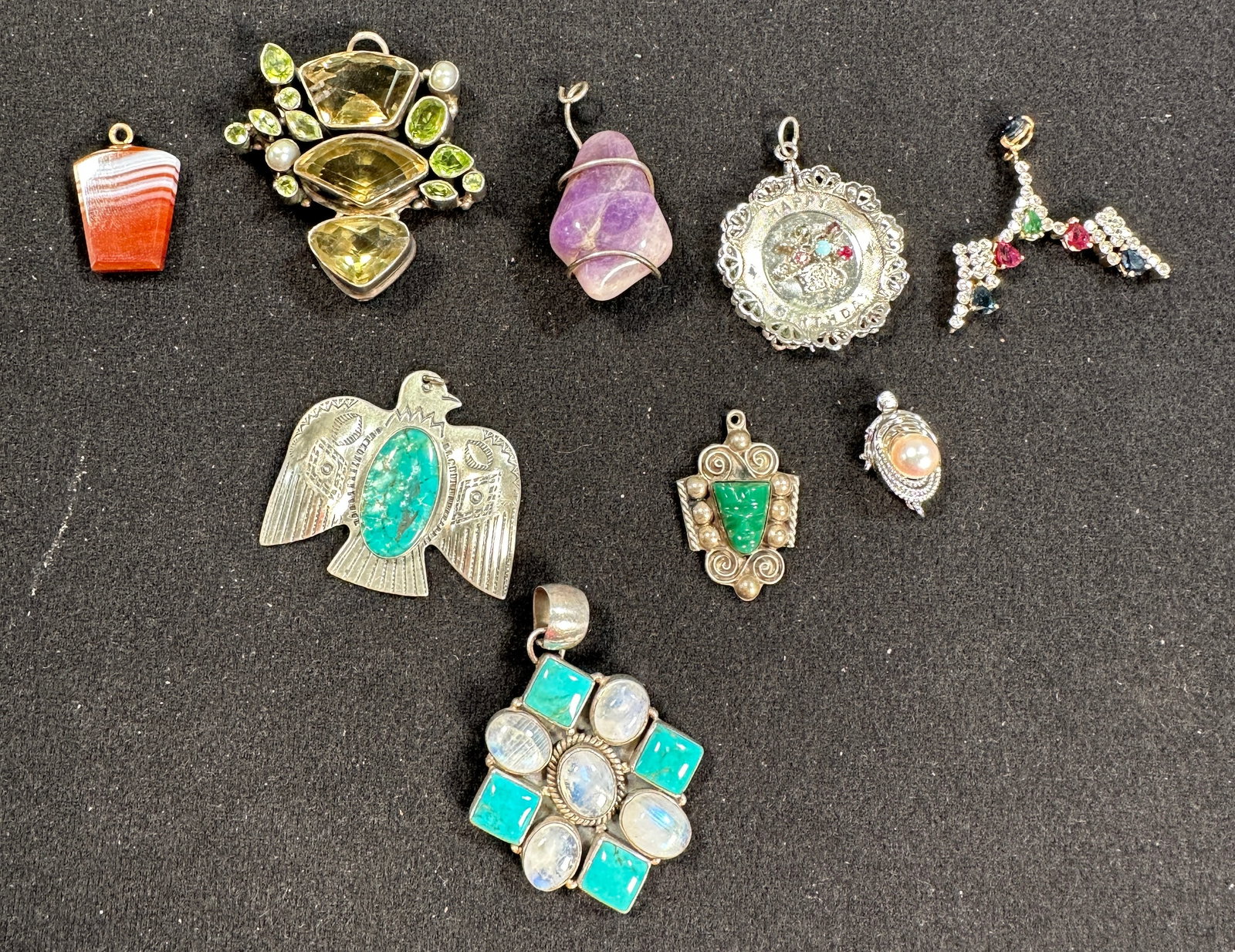 Group of Assorted Pendants: Collection of 9 pendants featuring various stones and designs, including turquoise, amethyst, and other colorful gems. Metal compositions vary; some marked sterling. Sizes range from 0.5 to 2
