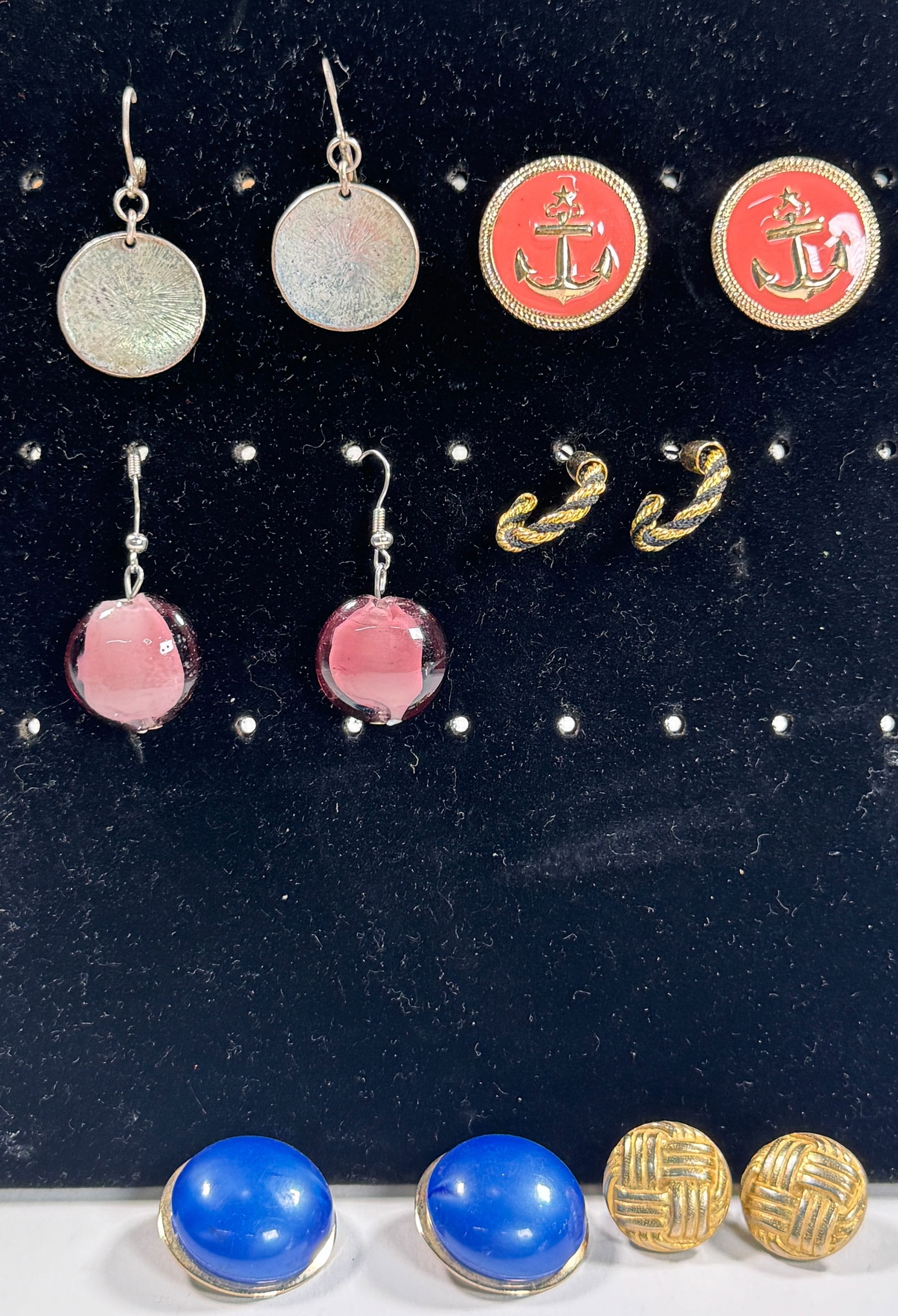 Assorted Costume Earrings - 6 Pairs: Collection of six pairs of costume earrings, including silver-tone discs, red anchor studs, pink glass drops, gold-tone hoops, blue plastic studs, and textured gold-tone studs. Weight: 1.9 oz.
